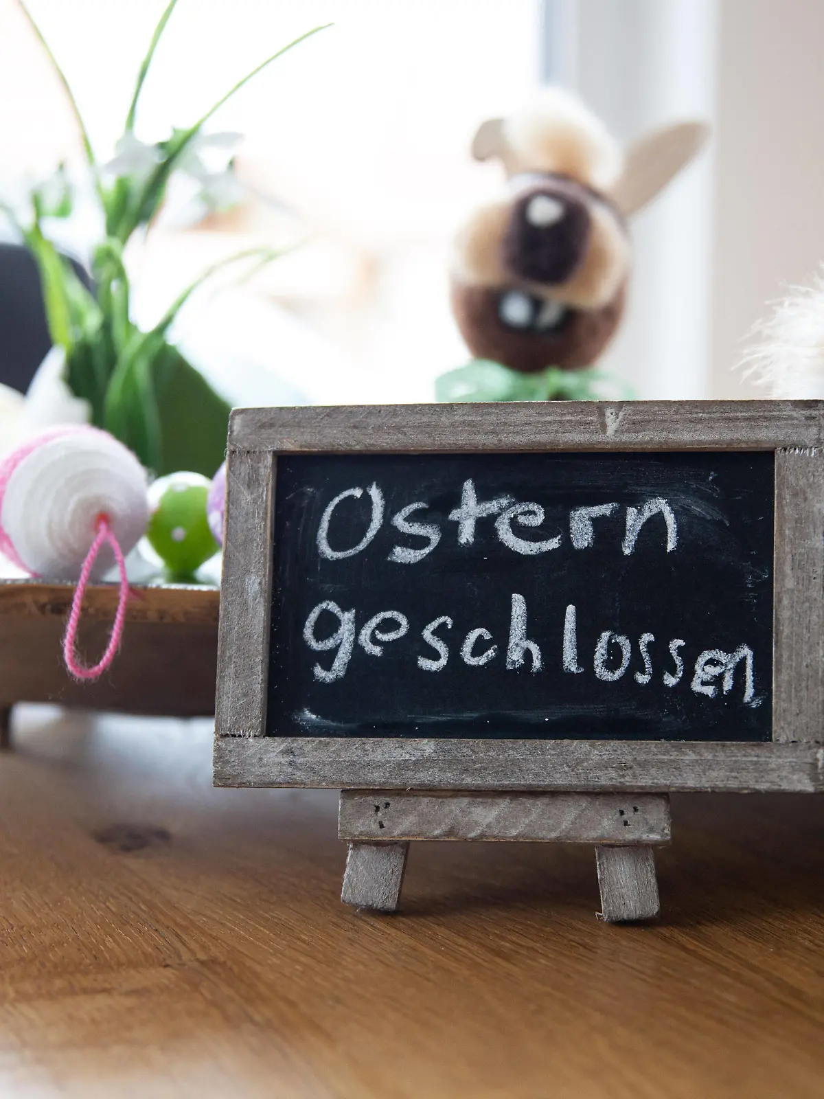 Bamberg, Deutschland 23. Maerz 2021: Ein Tisch in einer Wohnung ist für Ostern dekoriert, vor der Osterdekoration steht auf einer kleinen Tafel - Ostern geschlossen. Bayern *** Bamberg, Germany 23 March 2021 A table in an apartment is decorated for Easter, in front of the Easter decorations a small plaque reads Easter closed Bavaria. Copyright: xFotostandx/xK.xSchmittx 