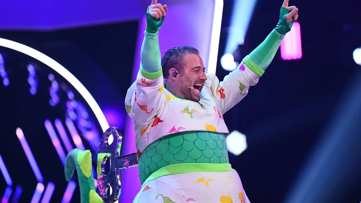 dpatopbilder - HANDOUT - 23.03.2021, Nordrhein-Westfalen, Köln: Der Sänger Sasha jubelt im Finale der ProSieben-Show «The Masked Singer» im Kostüm des Dinos über seinen Sieg. Bei «The Masked Singer» singen Prominente in aufwendigen Bühnenkostümen um die Wette. Die vierte Staffel der Kostümschau geht am Dienstag zu Ende. Foto: Willi Weber/ProSieben/dpa - ACHTUNG: Nur zur redaktionellen Verwendung im Zusammenhang mit einer Berichterstattung über die Sendung und nur mit vollständiger Nennung des vorstehenden Credits. Das Foto darf nicht verändert und nur im vollen Ausschnitt verwendet werden. Keine Archivierung +++ dpa-Bildfunk +++