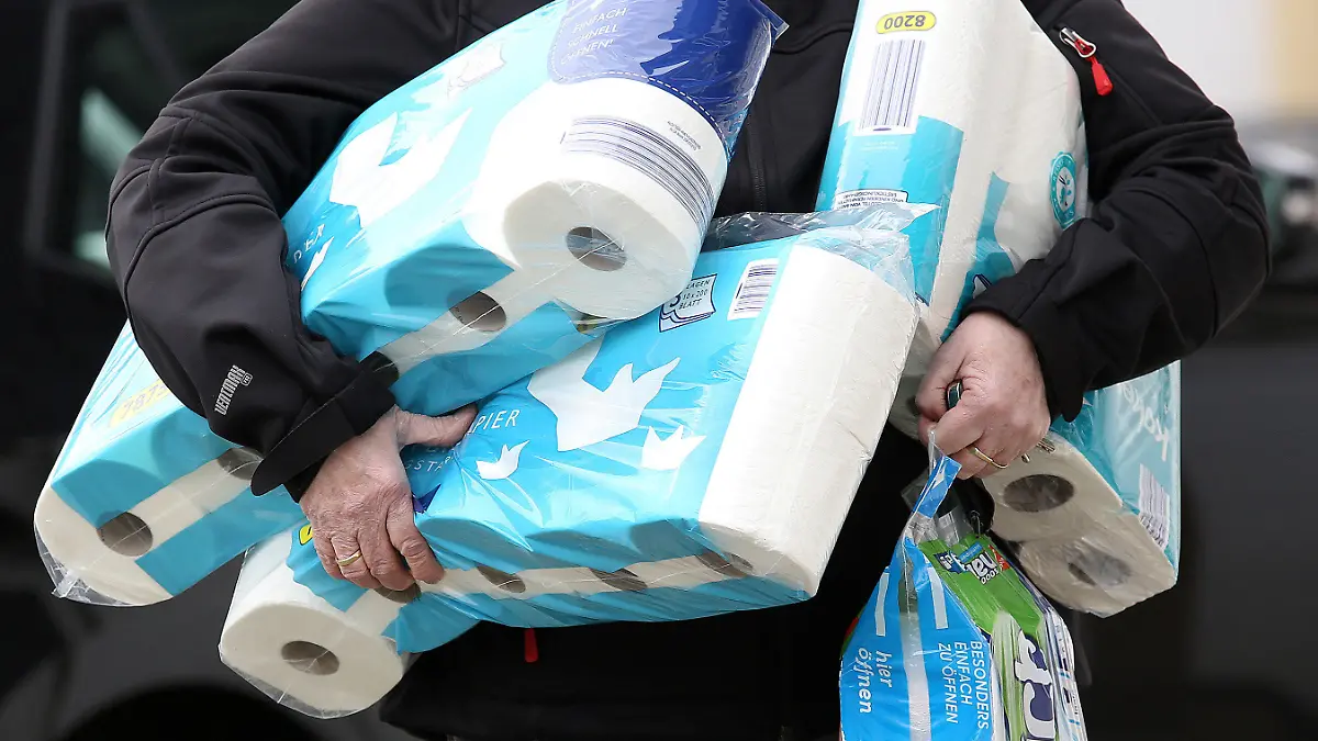 ARCHIV - 18.03.2020, Nordrhein-Westfalen, Siegen: Ein Mann trägt eingekauftes Toilettenpapier und Küchenrollen aus einem Supermarkt. (zu dpa «Klopapier-Streik und Masken-Sheriff: Kurioses im Corona-Jahr») Foto: Rene Traut/dpa +++ dpa-Bildfunk +++