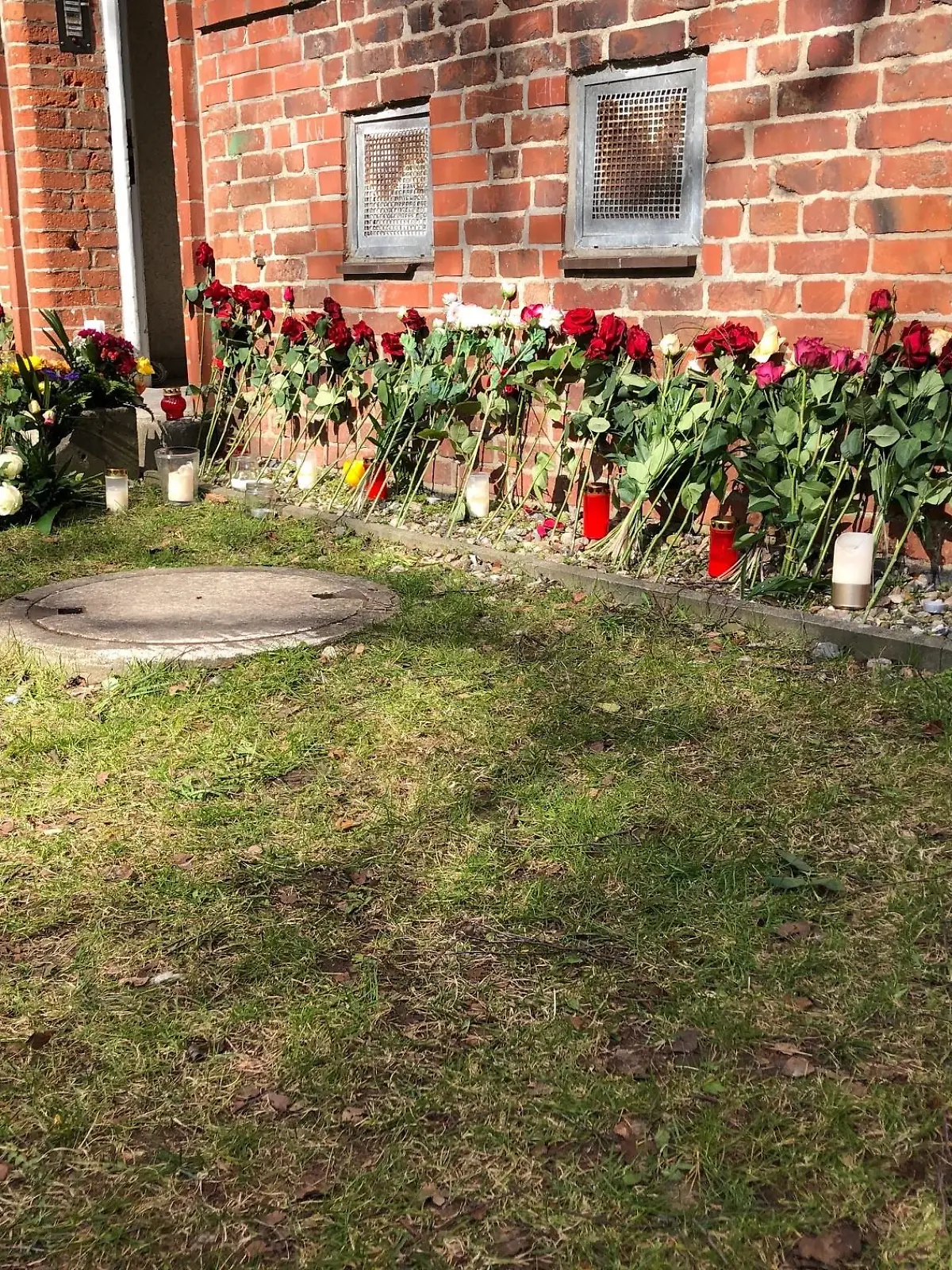 Vor dem Hauseingang in Kiel haben viele Blumen niedergelegt.