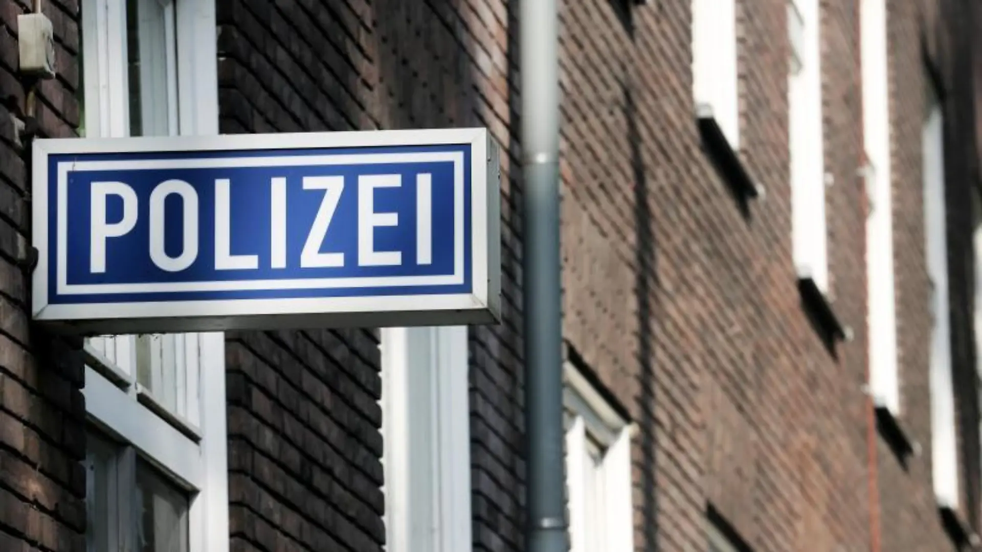 Ein Polizei-Schild hängt an einem Polizeipräsidium
