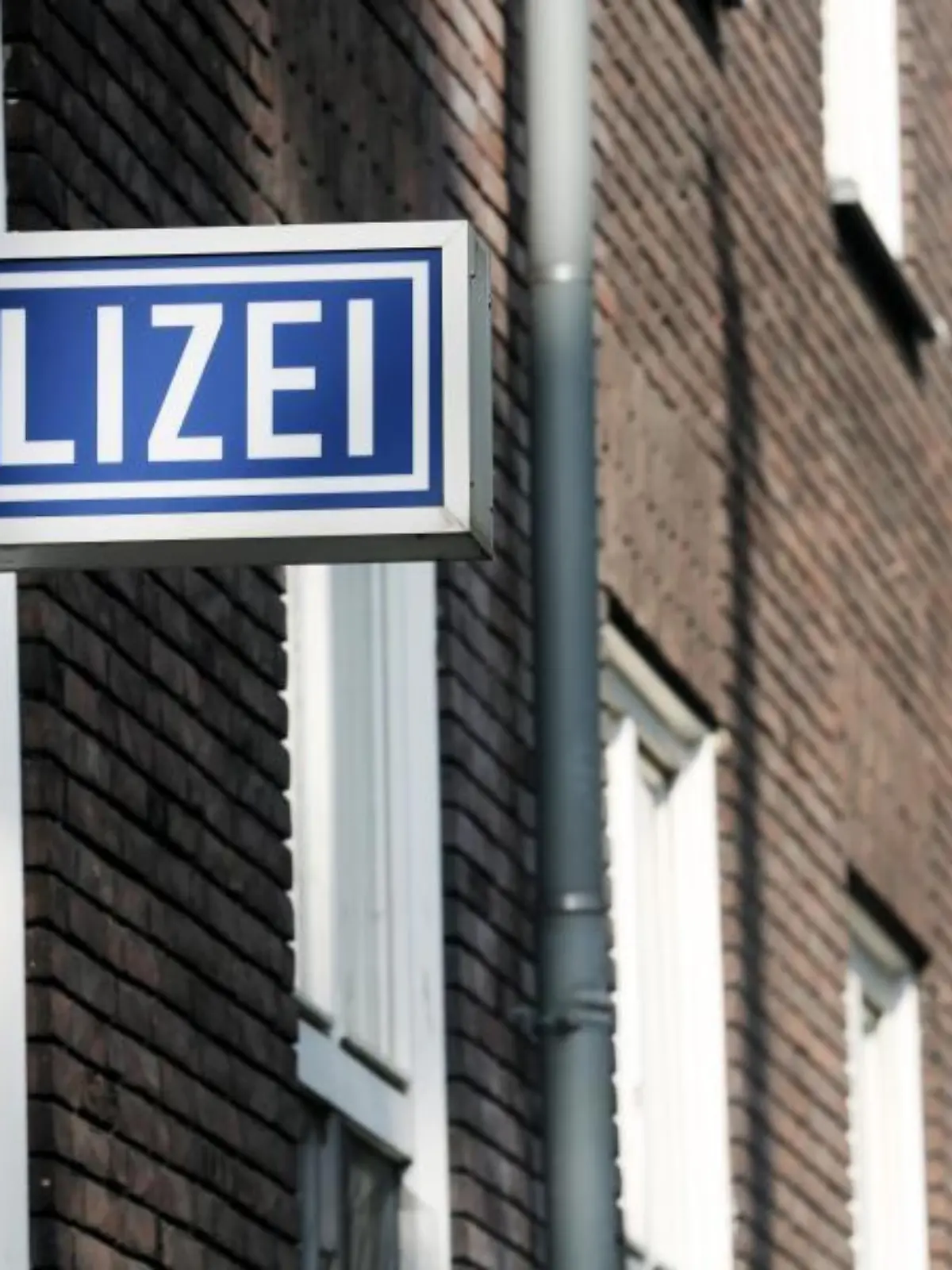 Ein Polizei-Schild hängt an einem Polizeipräsidium