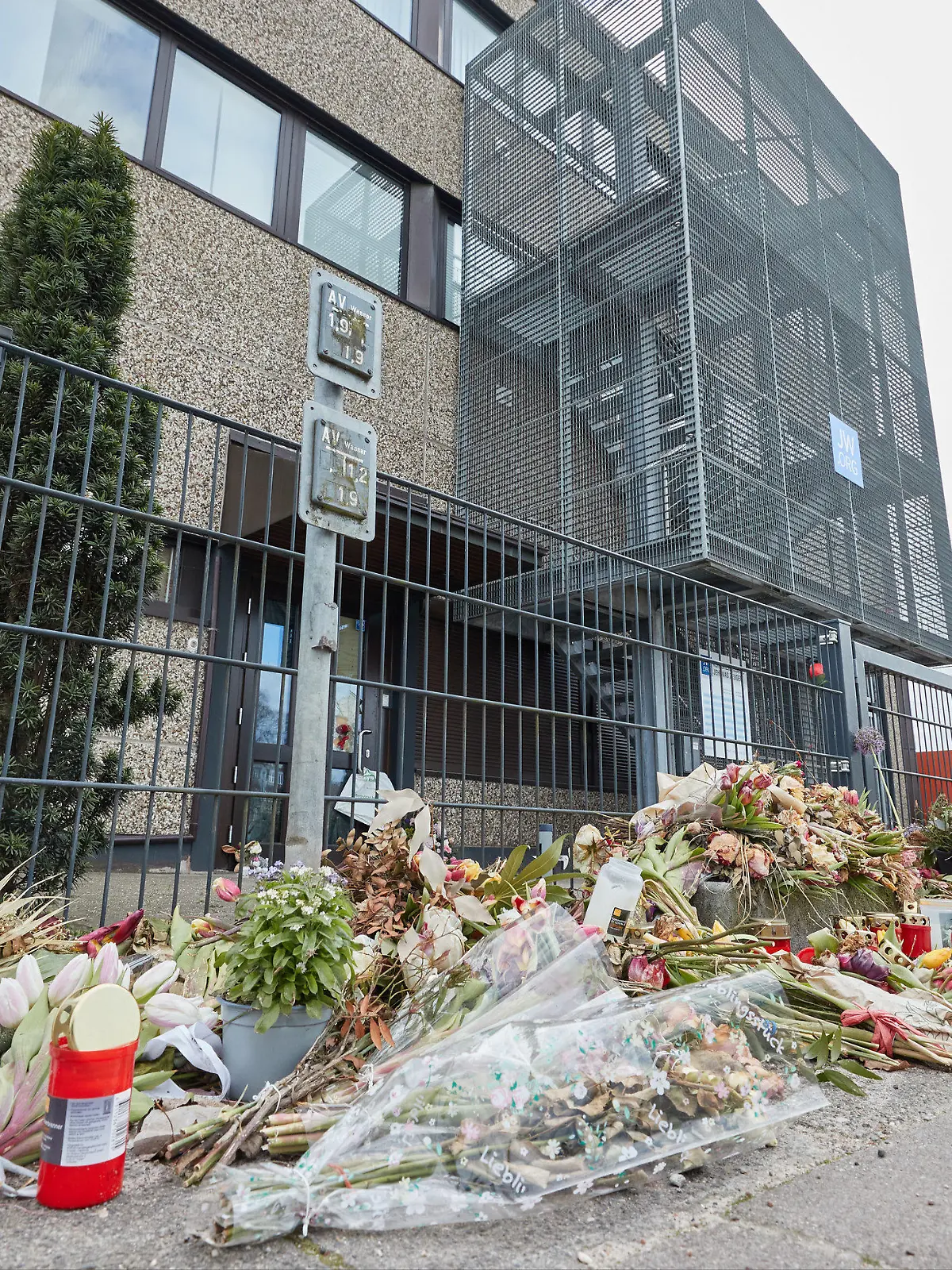 PRODUKTION - 05.04.2023, Hamburg: Blumen liegen vor dem Gemeindehaus der Zeugen Jehovas in der Deelböge. Die Amoktat bei einer Gemeindeversammlung der Zeugen Jehovas Anfang März in Alsterdorf beschäftigt am Donnerstag den Innenausschuss der Hamburgischen Bürgerschaft. Dabei will der Senat den Abgeordneten Auskunft über den aktuellen Stand der Ermittlungen zu der Bluttat gegeben, bei der am 9. März der 35-Jährige Philipp F. sieben Menschen und schließlich sich selbst getötet hatte. Foto: Georg Wendt/dpa +++ dpa-Bildfunk +++