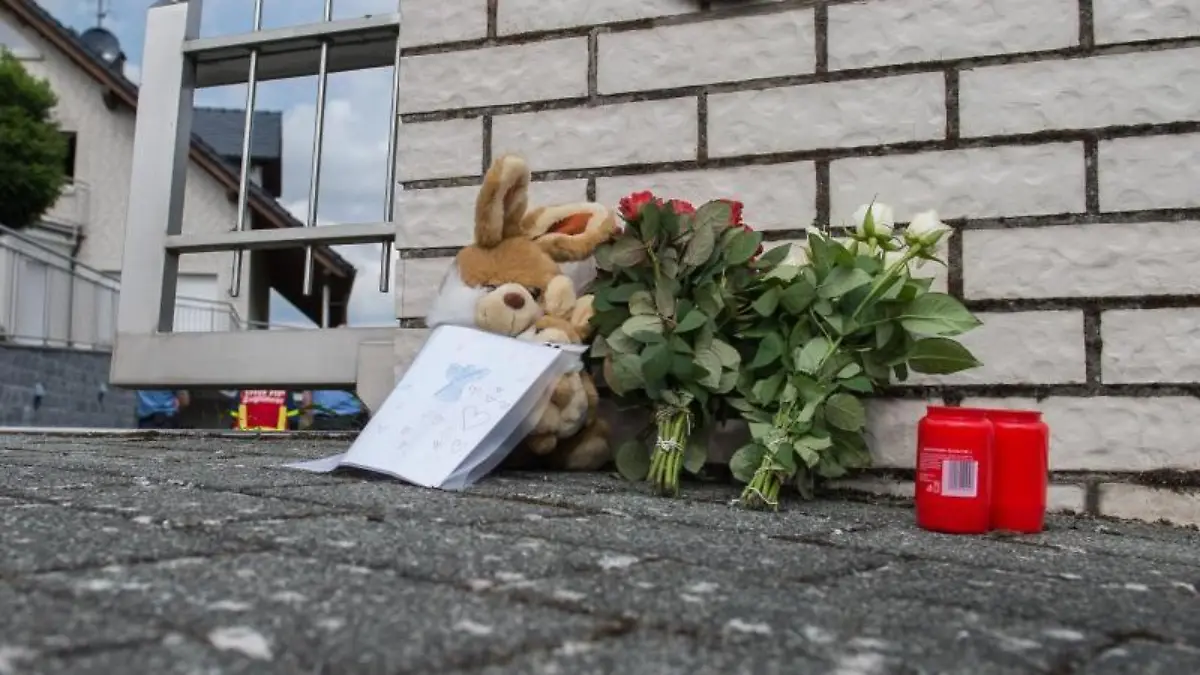 Blumen und Kerzen stehen vor einem Einfamilienhaus