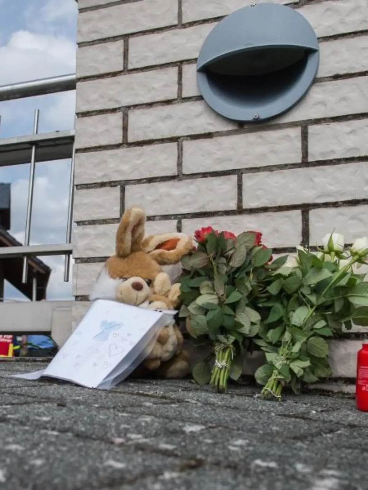 Blumen und Kerzen stehen vor einem Einfamilienhaus