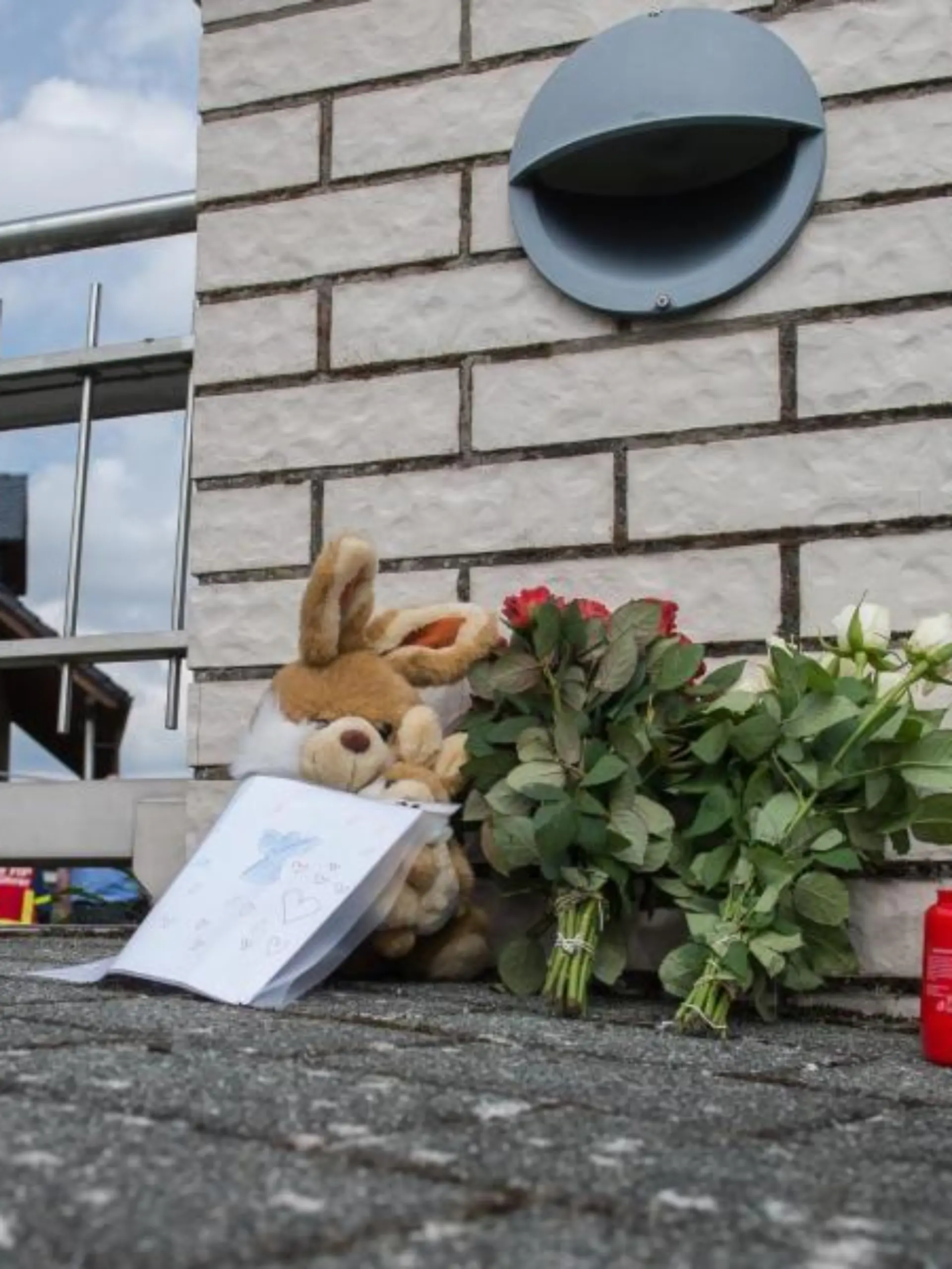 Blumen und Kerzen stehen vor einem Einfamilienhaus