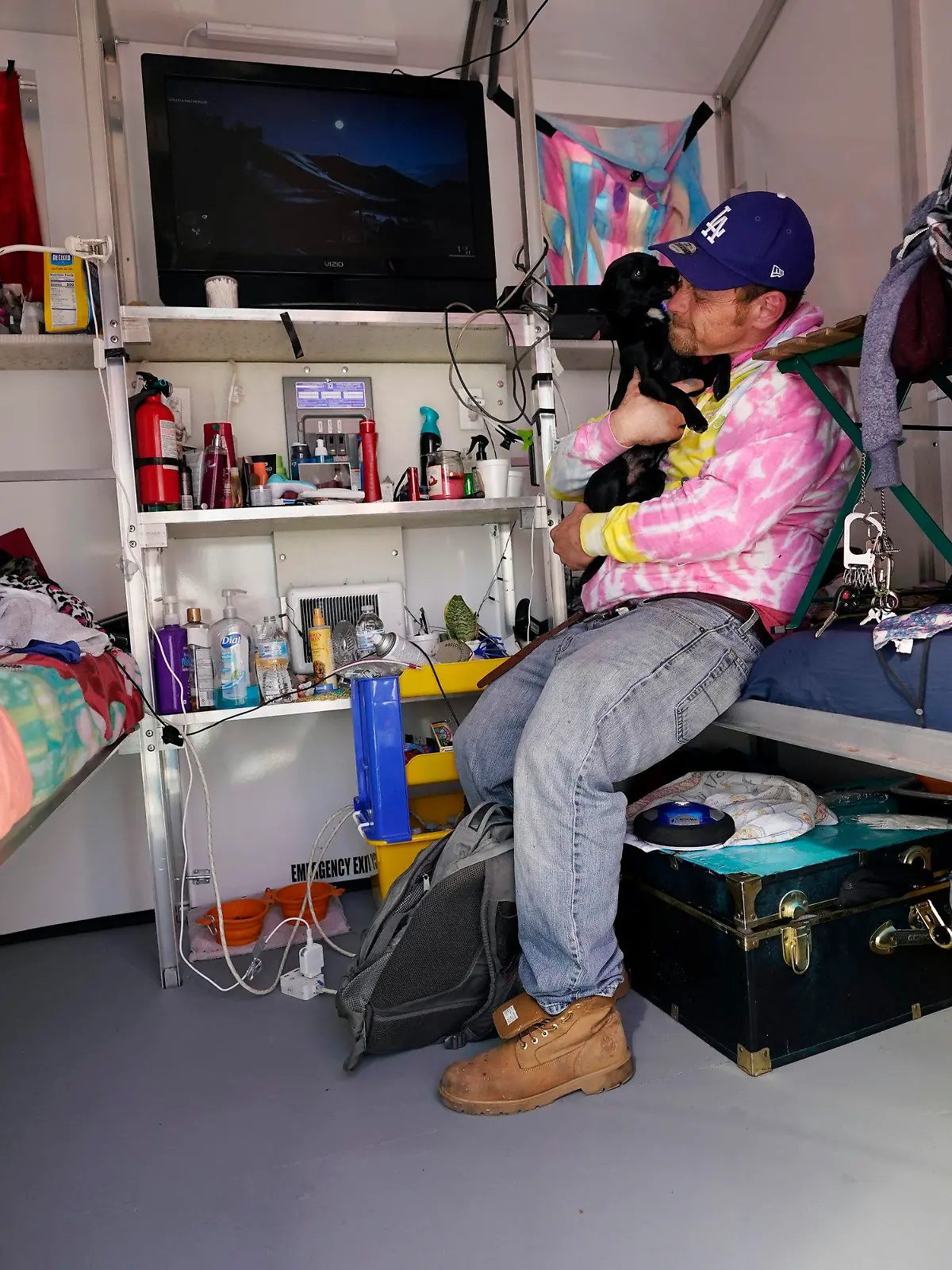 John Golka hugs his dog Smalls inside a tiny home, Thursday, Feb. 25, 2021, in the North Hollywood section of Los Angeles. (AP Photo/Marcio Jose Sanchez)