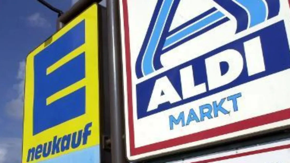 Die Schilder von Edeka und Aldi Nord werben im Seebad Heringsdorf auf der Insel Usedom für den Einkauf am Sonntag (aufgenommen am 28.06.2004). In der Sommersaison nutzen auch die Supermärkte in Mecklenburg-Vorpommern die "Bäder- und Fremdenverkehrsregelung". Die auf die Jahre 2003 bis 2006 befristete Ausnahmebewilligung ermöglicht es einzelnen Gemeinden, im Zeitraum vom 01. Februar bis 30. November mögliche Geschäftsöffnungszeiten samstags bis 20.00 Uhr und sonn- und feiertags von 12.00 Uhr bis 18.30 Uhr anzubieten. Ausgenommen sind bestimmte Feiertage. Foto: Stefan Sauer dpa