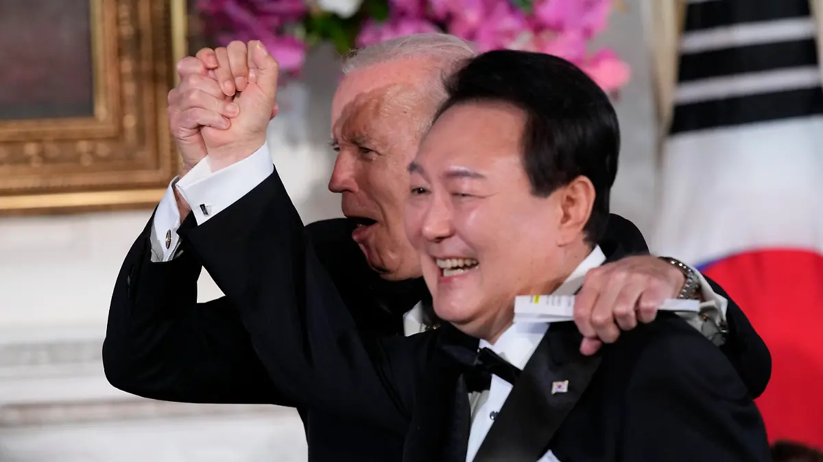 26.04.2023, USA, Washington: Joe Biden (l), Präsident der USA, reagiert, nachdem Yoon Suk Yeol, Präsident von Südkorea, das Lied American Pie von Don Mclean im State Dining Room des Weißen Hauses in Washington gesungen hat, nach dem Staatsdinner. Foto: Susan Walsh/AP/dpa +++ dpa-Bildfunk +++