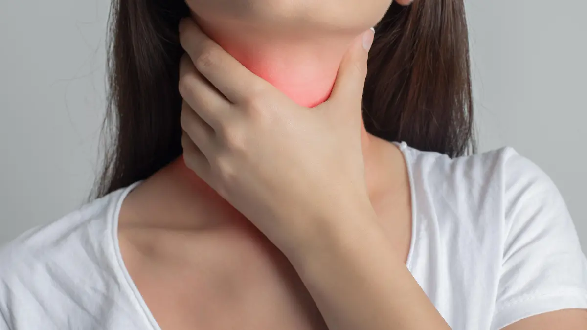 Woman holds her throat