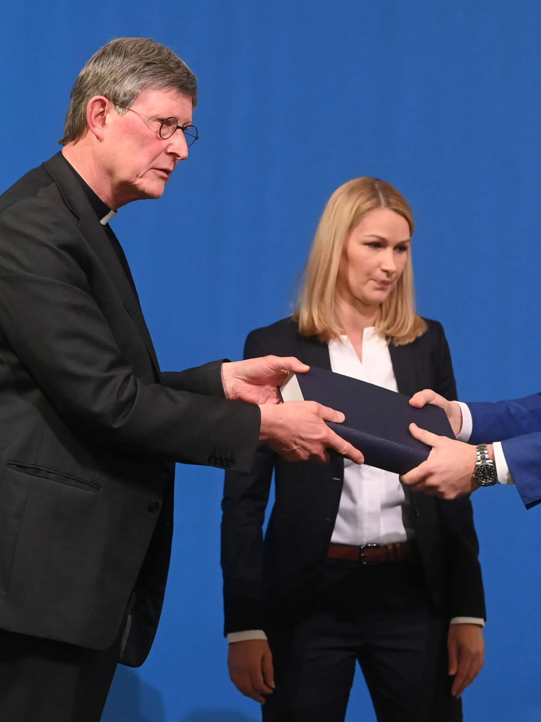 Lawyer Kerstin Stirner (C) looks on as Bjoern Gercke (R), an attorney mandated by the Church, hands over to Cologne's archbishop Rainer Maria Woelki a report on abuse by clergy during a news conference, in Cologne, Germany March 18, 2021.  Ina Fassbender/Pool via REUTERS