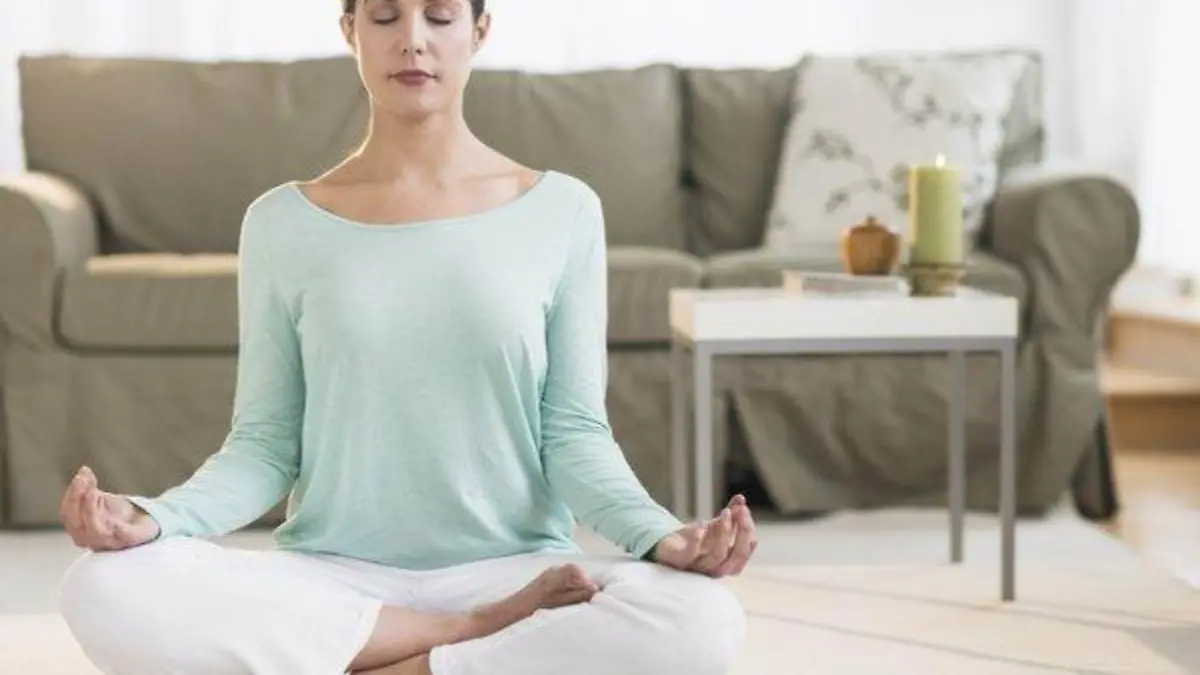Woman meditating in living room Keine Weitergabe an Drittverwerter.