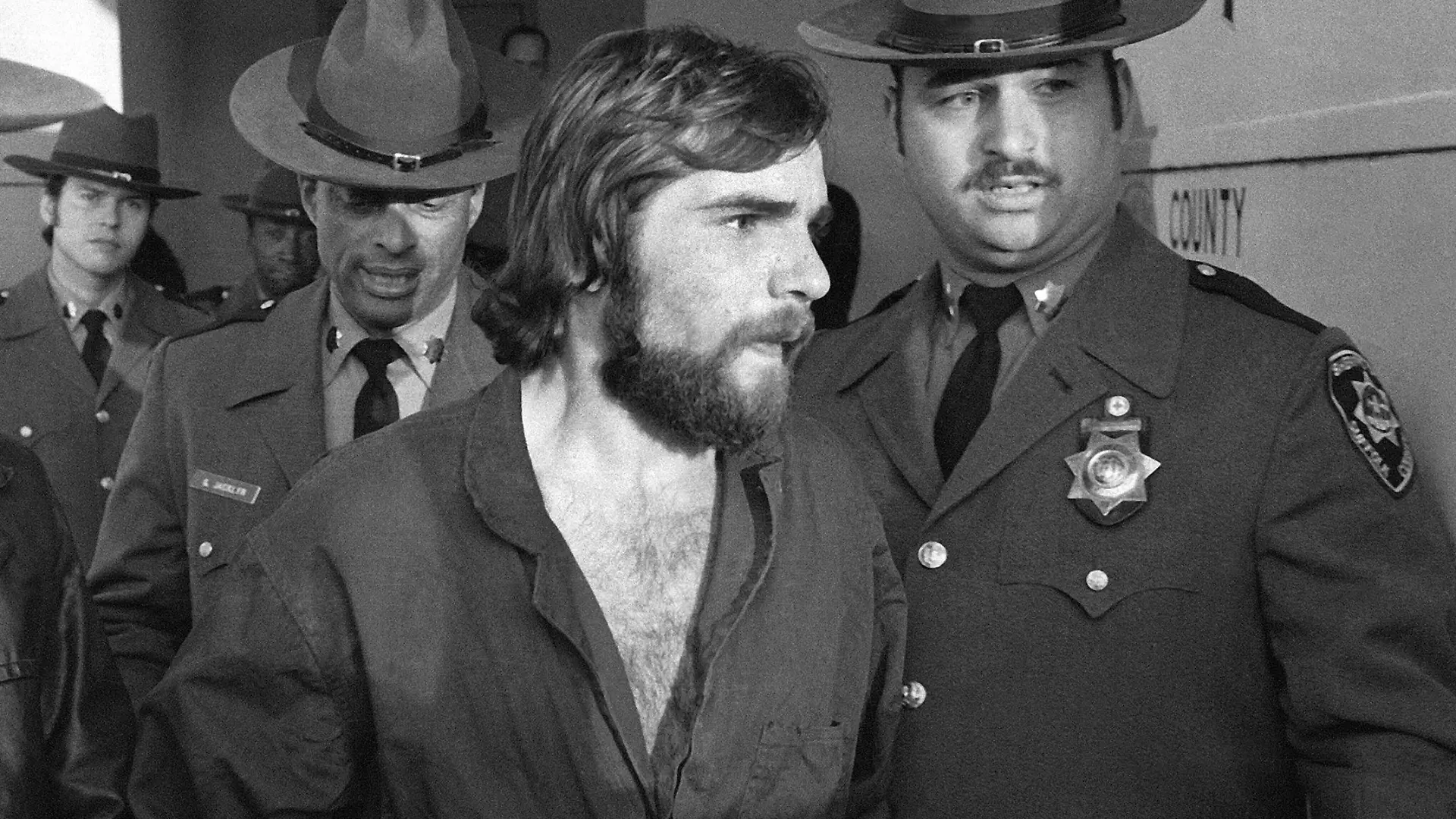 FILE - In this Nov. 15, 1974 file photo, Ronald DeFeo Jr., center, leaves Suffolk County district court after a hearing, on New York's Long Island. DeFeo, the man convicted of slaughtering his parents and four siblings in a home that later inspired the book and movie "The Amityville Horror"  died Friday, March 12, 2021, at Albany Medical Center,  where he was taken Feb. 2 from a prison in New York’s Catskill Mountains, prison officials said Monday, March 15. He was 69. (AP Photo/Richard Drew, File)
