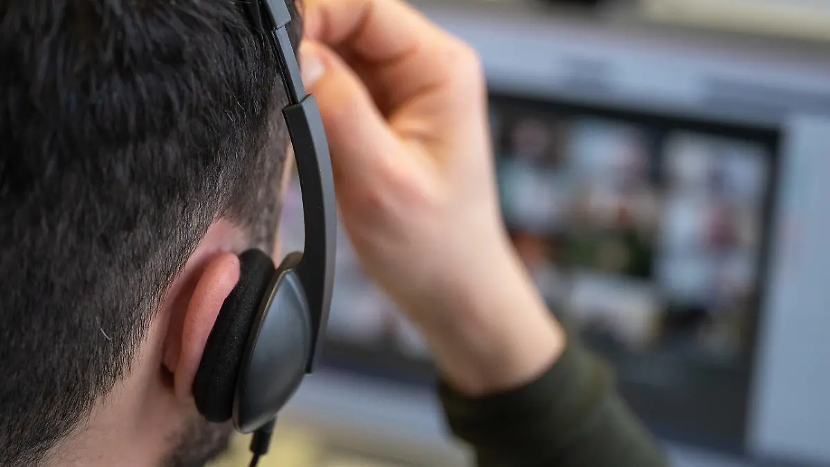 ILLUSTRATION - 05.02.2021, Baden-Württemberg, Dettenhausen: Ein junger Mann, der ein Headset trägt, nimmt an einer Videokonferenz teil. (zu dpa "Tücken des Video-Unterrichts: Schwarze Kacheln und heimliche Fotos") Foto: Sebastian Gollnow/dpa +++ dpa-Bildfunk +++