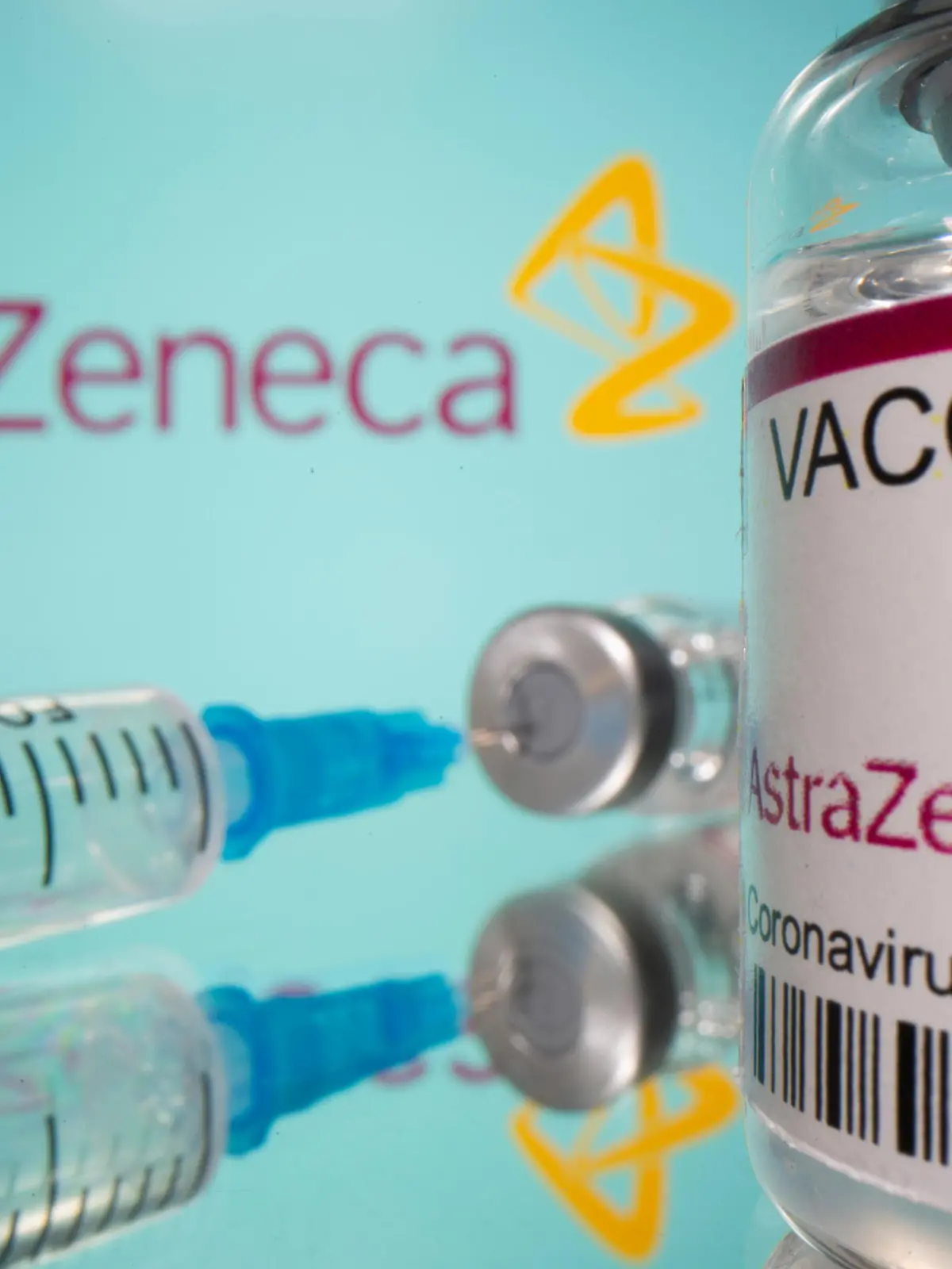 Vial labelled "AstraZeneca COVID-19 Coronavirus Vaccine" and a broken syringe are seen in front of a displayed AstraZeneca logo in this illustration taken March 15, 2021. REUTERS/Dado Ruvic/Illustration