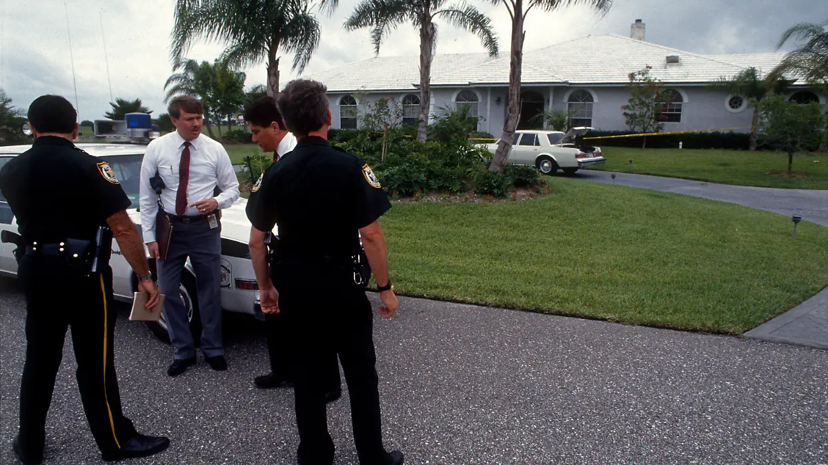 May 25, 2017 - Florida, U.S. - 5/26/90 - Palm Beach County detectives examine the doorway where someone dressed as a clown shot Marlene Warren in Wellington