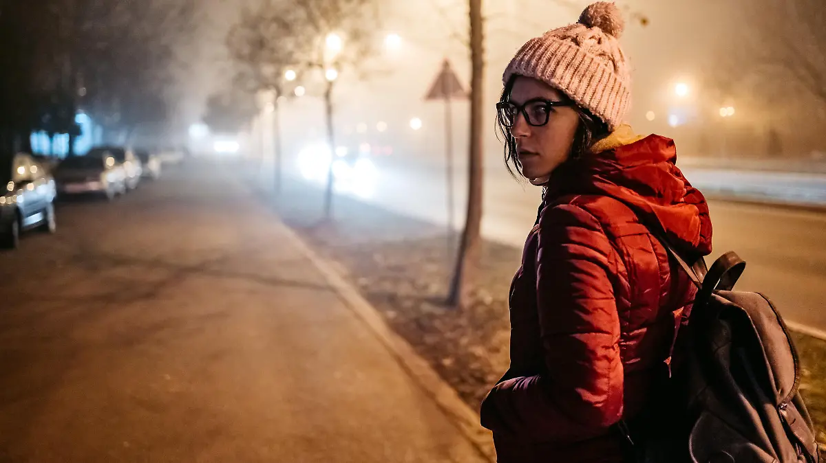 Frau dreht sich auf dem nächtlichen Nachhauseweg allein um