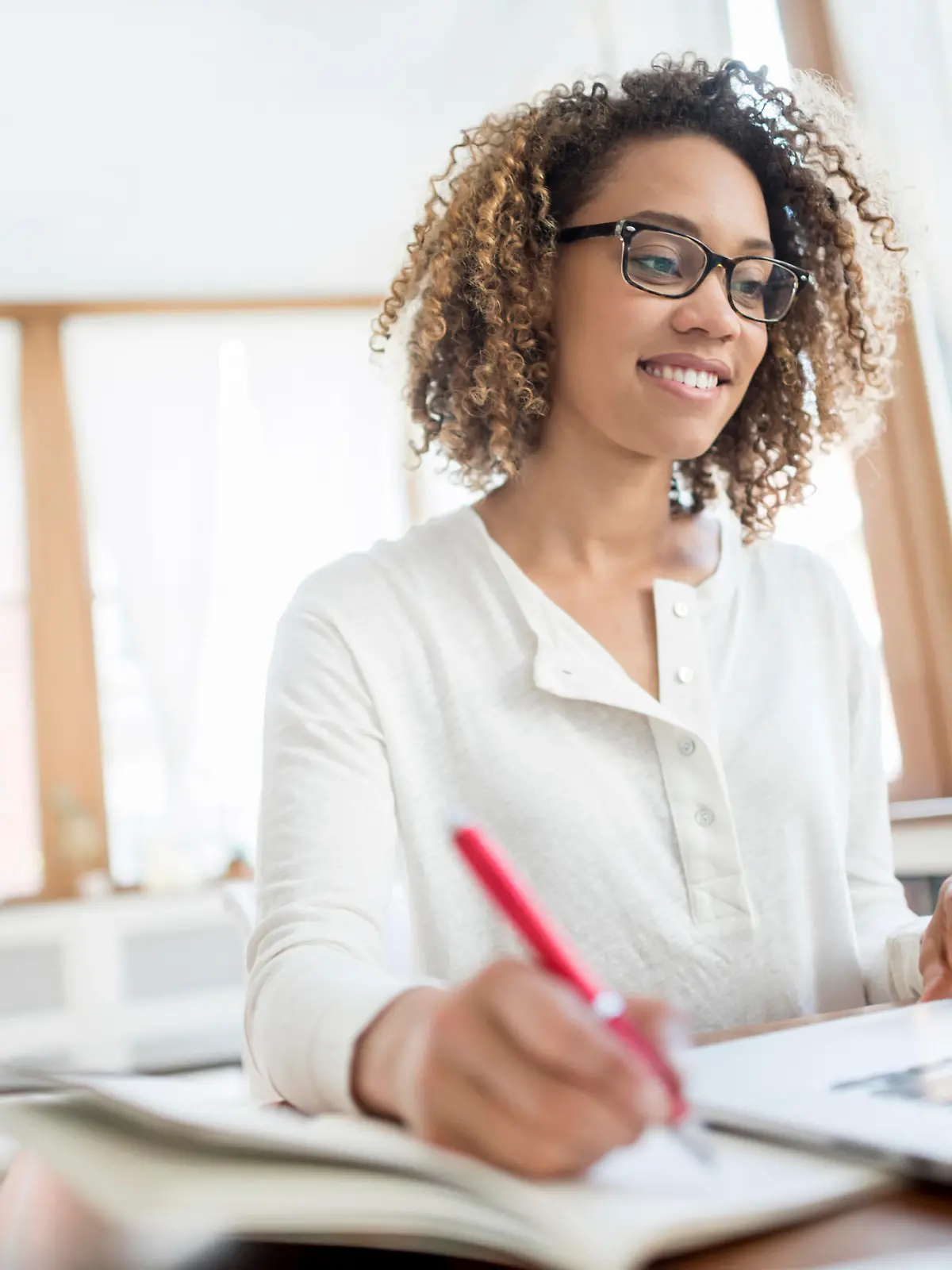 Young African American business woman working at home on a laptop computer and wearing glasses