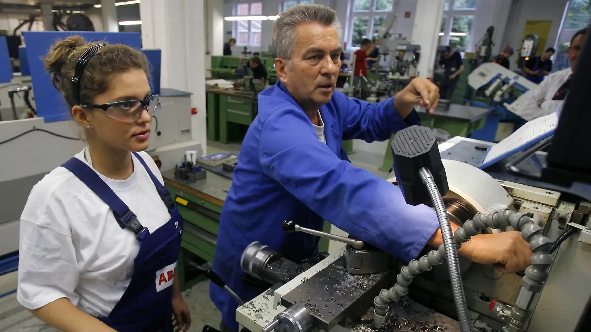 ARCHIV - Eine Auszubildende im Beruf der Zerspanungsmechanikerin, steht gemeinsam mit ihrem Meister an einer Drehbank im Ausbildungszentrum der Firma ABB in Berlin (Archivbild vom 23.09.2008). In wenigen Jahren werden
Millionen Fachkräfte fehlen. Entwarnung gibt es zwar nicht, doch laut einer Studie wird die Lücke nicht so groß wie befürchtet - auch weil es wirtschaftlich weniger steil bergauf geht als erhofft.  Foto: Tim Brakemeier/dpa  +++(c) dpa - Bildfunk+++