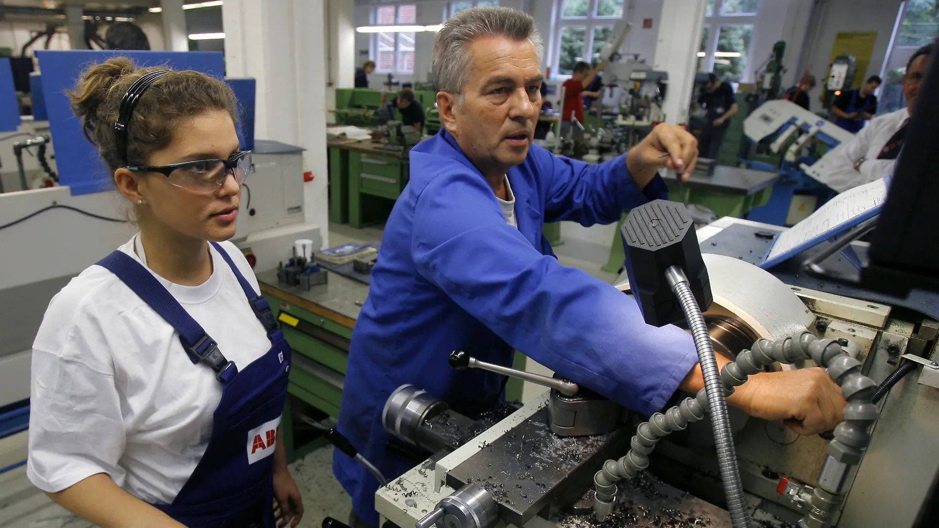 ARCHIV - Eine Auszubildende im Beruf der Zerspanungsmechanikerin, steht gemeinsam mit ihrem Meister an einer Drehbank im Ausbildungszentrum der Firma ABB in Berlin (Archivbild vom 23.09.2008). In wenigen Jahren werden
Millionen Fachkräfte fehlen. Entwarnung gibt es zwar nicht, doch laut einer Studie wird die Lücke nicht so groß wie befürchtet - auch weil es wirtschaftlich weniger steil bergauf geht als erhofft. Foto: Tim Brakemeier/dpa +++(c) dpa - Bildfunk+++