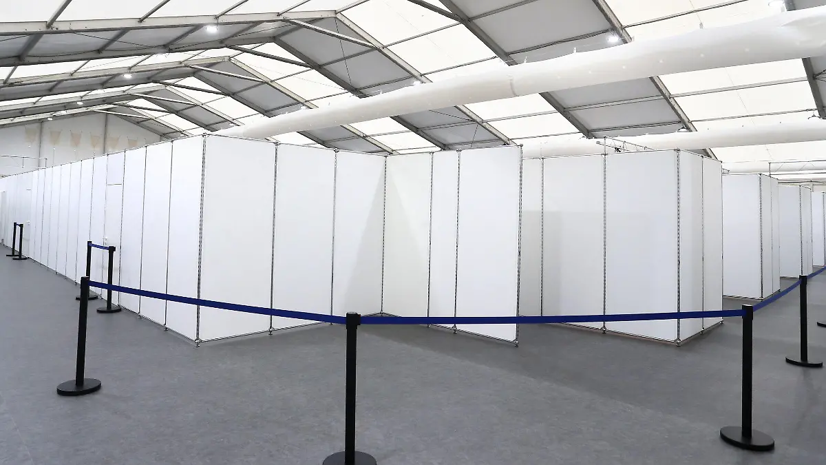 16.12.2020, Bayern, Würzburg: Angehörige von Hilfsorganisationen stehen in einem Gang des gemeinsamen Impfzentrums von Stadt und Landkreis Würzburg. Die Leichtbauhalle mit Inneneinrichtung wurde in rund acht Tagen fertiggestellt und nun der Öffentlichkeit präsentiert. Foto: Karl-Josef Hildenbrand/dpa +++ dpa-Bildfunk +++