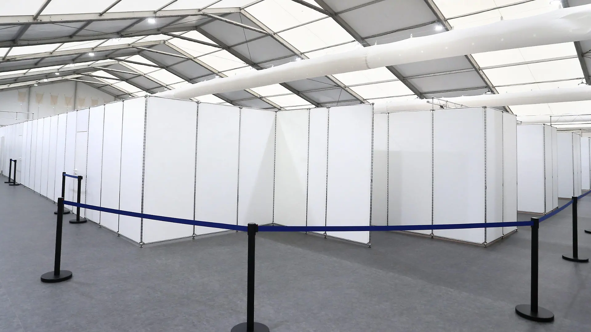 16.12.2020, Bayern, Würzburg: Angehörige von Hilfsorganisationen stehen in einem Gang des gemeinsamen Impfzentrums von Stadt und Landkreis Würzburg. Die Leichtbauhalle mit Inneneinrichtung wurde in rund acht Tagen fertiggestellt und nun der Öffentlichkeit präsentiert. Foto: Karl-Josef Hildenbrand/dpa +++ dpa-Bildfunk +++