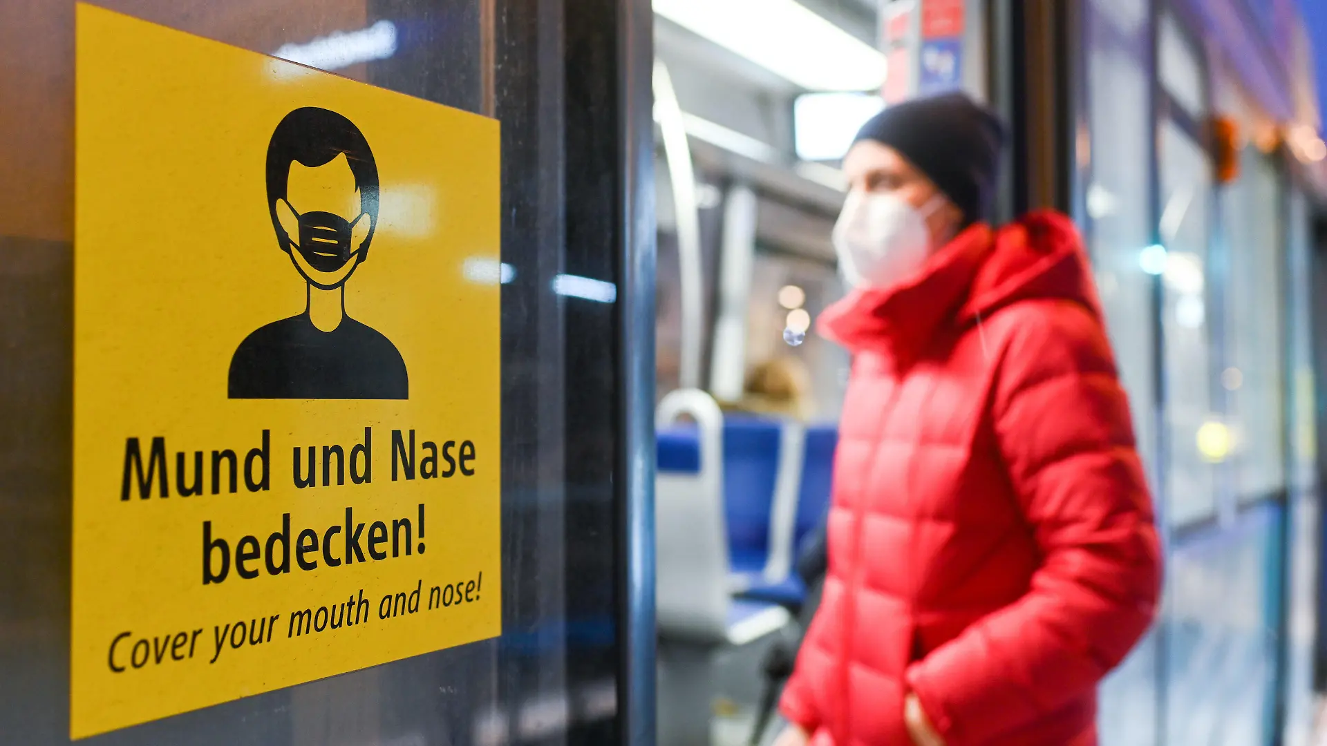 ARCHIV - 18.01.2021, Bayern, München: In einer arrangierten Situation steigt eine Frau, die eine FFP2-Maske trägt, in eine Trambahn ein.(zu dpa: «Bayern schafft Maskenpflicht im ÖPNV nach 9. Dezember ab») Foto: Tobias Hase/dpa +++ dpa-Bildfunk +++