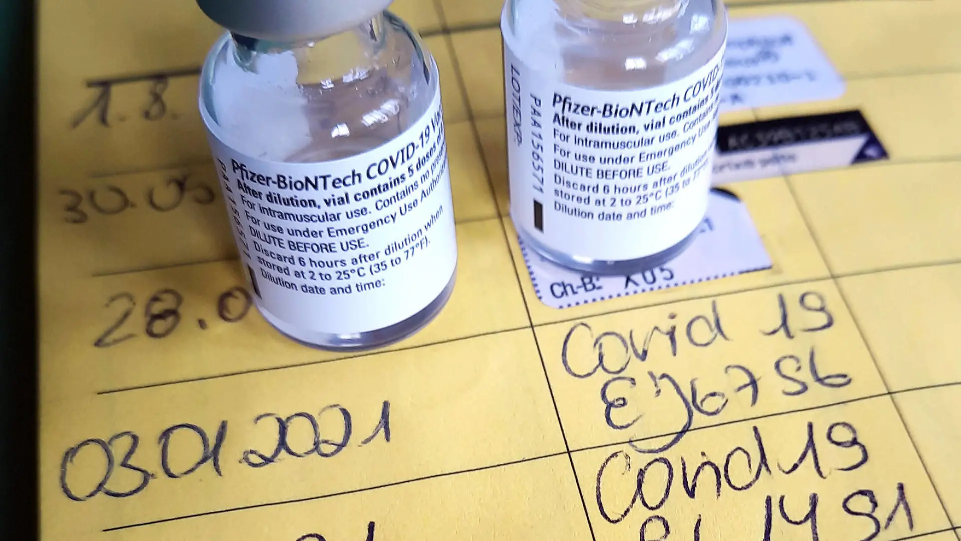 Symbolbild Corona-Impfung. Zwei Impfdosen, Impfspritze und der Eintrag der ersten und zweiten Corona-Impfung in einem Impfpass einer mit dem COVID-19-mRNA-Impfstoff der Firma BioNTech geimpften Person. Dortmund, 25.01.2021 *** Symbolic image Corona vaccination Two vaccine doses, vaccination syringe and the entry of the first and second Corona vaccination in a vaccination certificate of a person vaccinated with the COVID 19 mRNA vaccine from BioNTech Dortmund, 25 01 2021