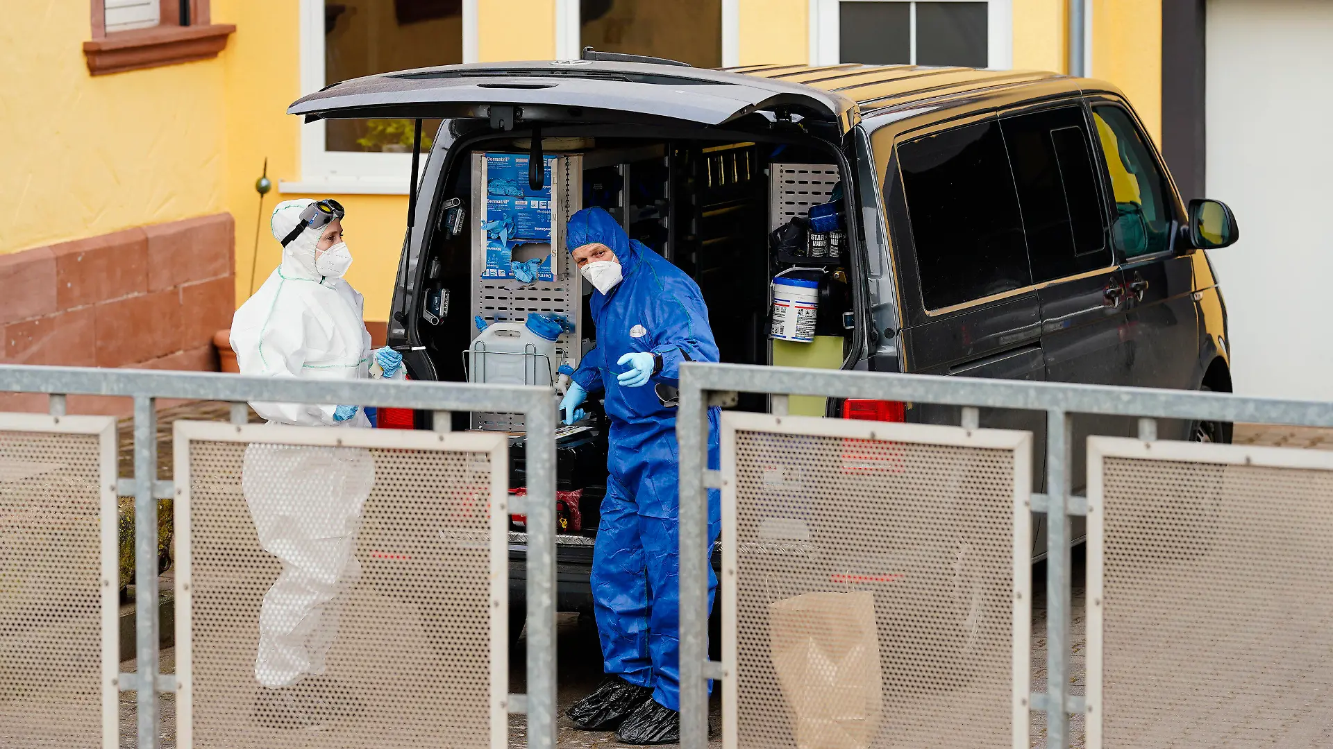 10.03.2021, Rheinland-Pfalz, Weilerbach: Mitarbeiter der Spurensicherung stehen auf einem Anwesen am Ortseingang vor einem Wohnhaus. Nach dem Fund zweier Leichen in einem Haus in Weilerbach bei Kaiserslautern sucht die Polizei weiter mit Hochdruck nach einem Verdächtigen. Foto: Uwe Anspach/dpa +++ dpa-Bildfunk +++