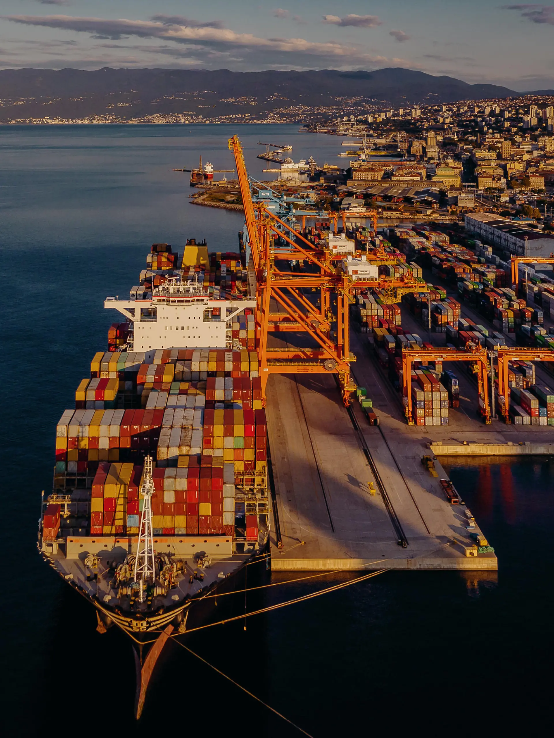 In einem Hafen sieht man mehrere Schiffe, die mit Containern beladen sind.
