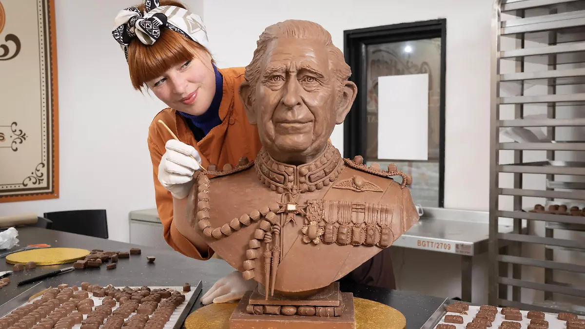 King Charles III coronation. EDITORIAL USE ONLY Chocolatier Jennifer Lindsey-Clarke adds the finishing touches to bust of King Charles III made from Celebrations chocolates ahead of the Coronation. Issue date: Wednesday April 26, 2023. The sculpture, commissioned by the chocolate brand, took four weeks to create and weighs over 23kg - the equivalent of 2,875 individual Celebrations chocolates. Photo credit should read: Matt Alexander/PA Wire URN:71904312