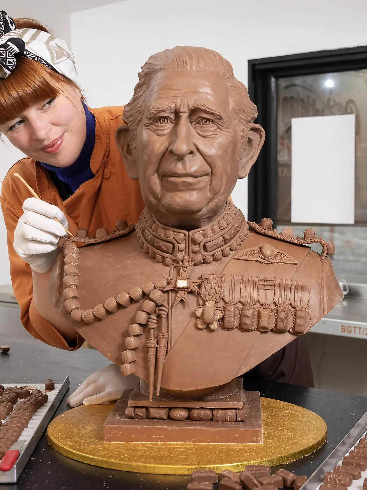 King Charles III coronation. EDITORIAL USE ONLY Chocolatier Jennifer Lindsey-Clarke adds the finishing touches to bust of King Charles III made from Celebrations chocolates ahead of the Coronation. Issue date: Wednesday April 26, 2023. The sculpture, commissioned by the chocolate brand, took four weeks to create and weighs over 23kg - the equivalent of 2,875 individual Celebrations chocolates. Photo credit should read: Matt Alexander/PA Wire URN:71904312