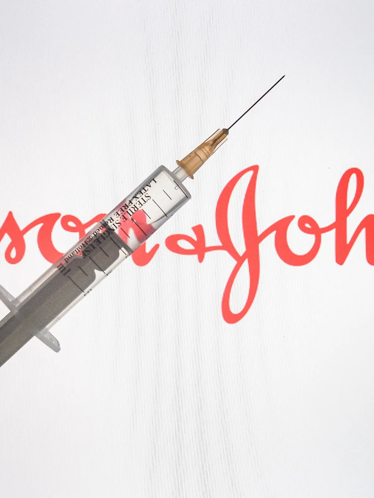  January 8, 2021, Ireland: In this photo illustration, a medical syringe is seen with a Johnson Johnson logo displayed on a screen in the background. Ireland - ZUMAs197 20210108_zaa_s197_006 Copyright: xCezaryxKowalskix