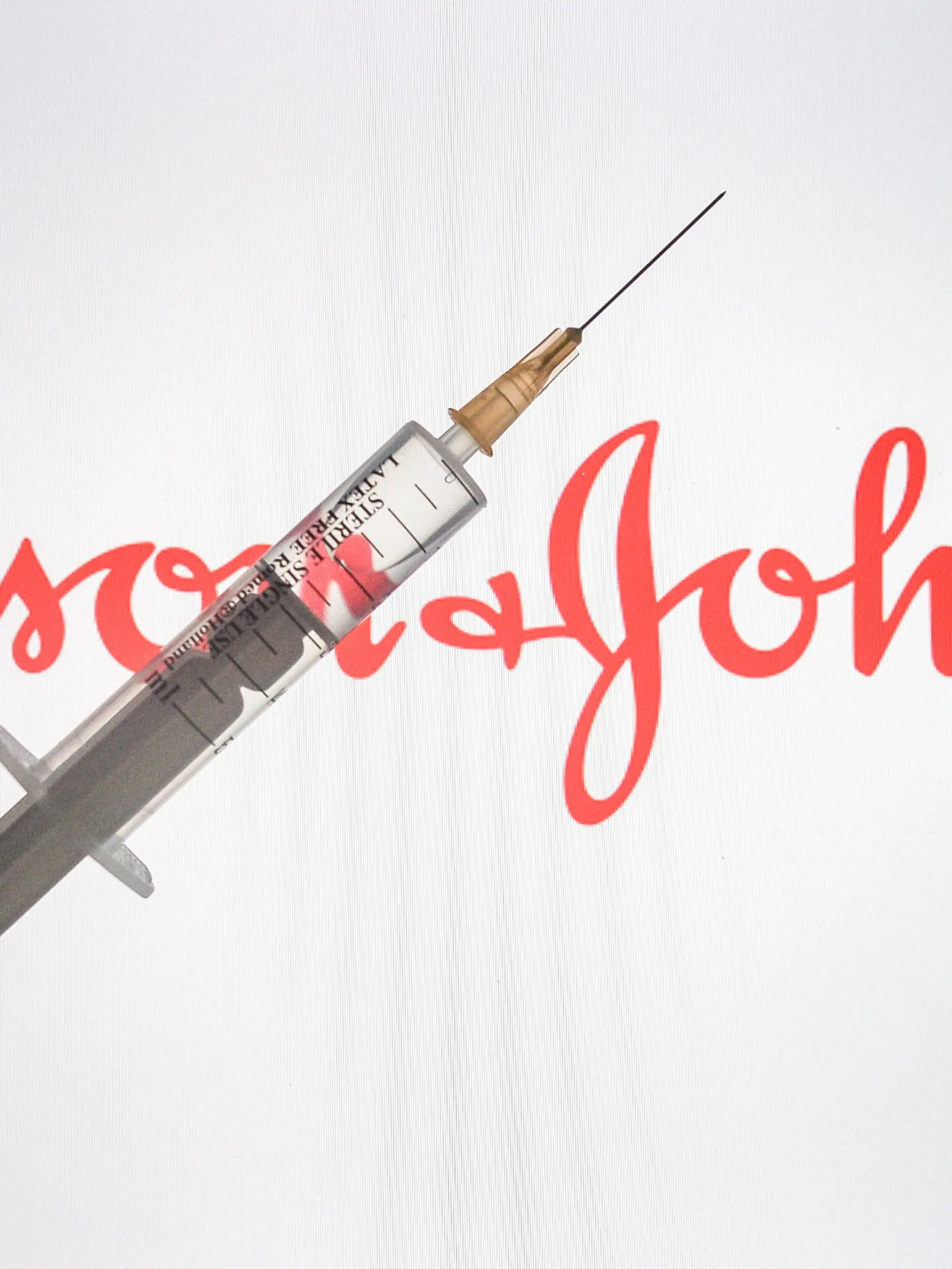  January 8, 2021, Ireland: In this photo illustration, a medical syringe is seen with a Johnson Johnson logo displayed on a screen in the background. Ireland - ZUMAs197 20210108_zaa_s197_006 Copyright: xCezaryxKowalskix