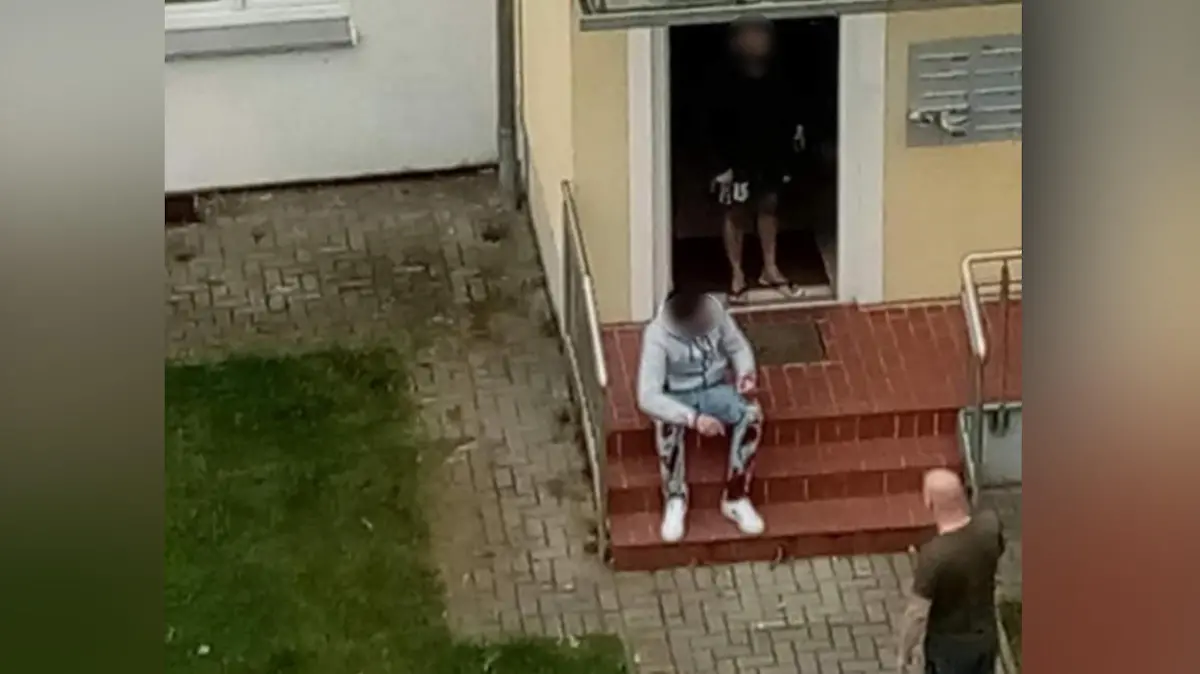 Hier sitzt der mutmaßliche Ex-Freund des Opfers mit blutiger Hose vor dem Hauseingang.