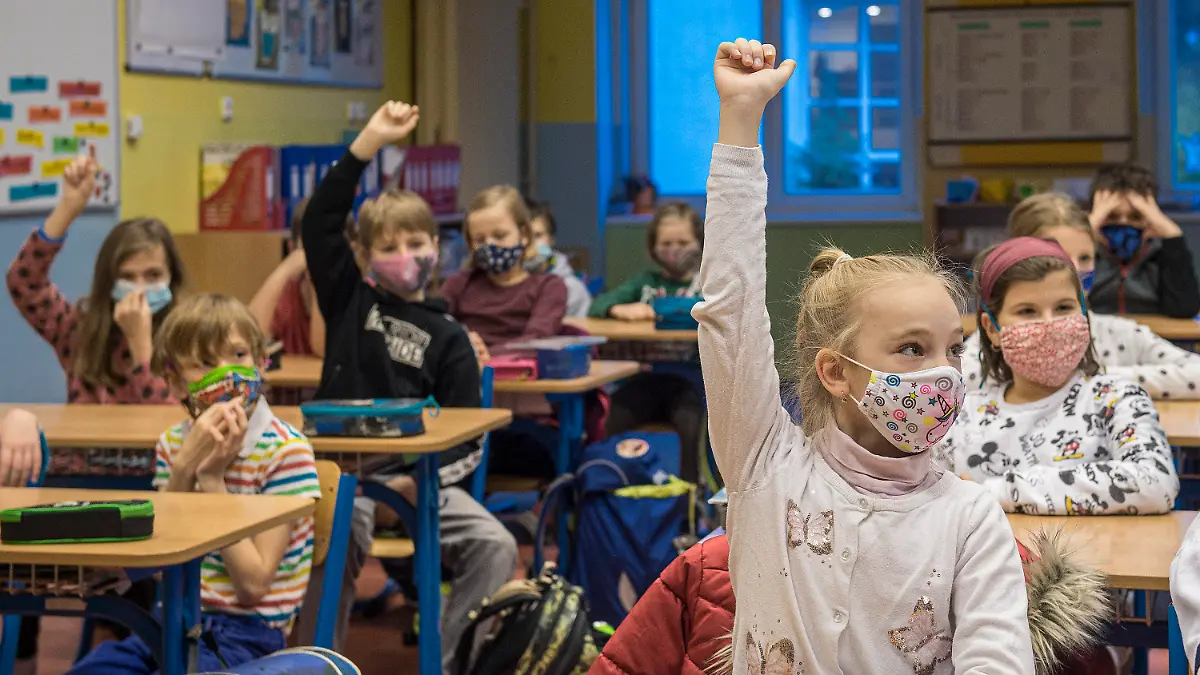 30.11.2020, Tschechien, Liberec: Schülerinnen und Schüler der Grundrunde Husova sitzen in einem Klassenraum und nehmen mit Gesichtsmasken am Unterricht teil. In Tschechien kehren in der Corona-Pandmie Schüler der dritten, vierten, fünften und neunten Klasse in die Schulen zurück. Die Klassen sechs bis acht wechseln zwischen Präsenz- und Fernunterricht. Tschechien mit seinen 10,7 Millionen Einwohnern hatte noch vor kurzem eine der höchsten Infektionsraten in Europa zu beklagen. Zuletzt entspannte sich die Lage etwas. Foto: Radek Petráek/CTK/dpa +++ dpa-Bildfunk +++