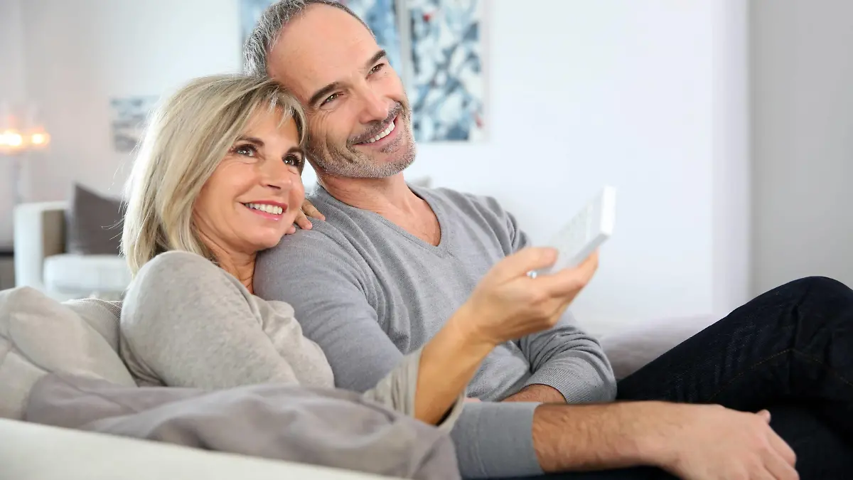 Älteres Paar schaut verträumt und romantisch einen Film im Fernsehen