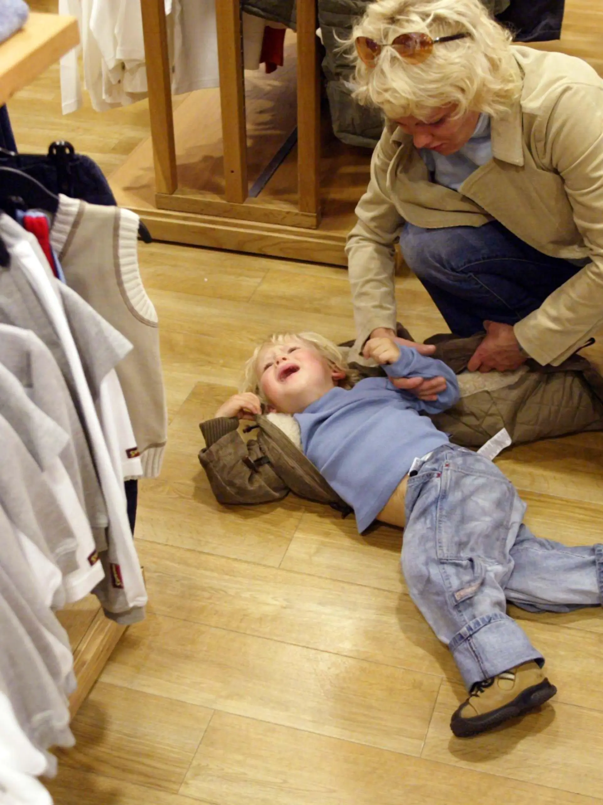 Nicht einfach für die Mutter: Ein kleines Kind hat sich mitten in einem Modegeschäft schreiend auf den Boden geworfen und will nicht mehr aufstehen. (Aufnahme vom 7.9.2003).