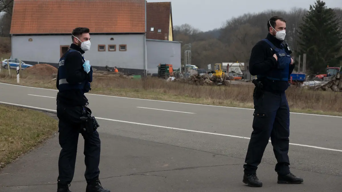 09.03.2021, Rheinland-Pfalz, Weilerbach: Polizisten sichern die Straße. In einem Wohnhaus in Weilerbach bei Kaiserslautern hat die Polizei zwei Leichen gefunden. Nach einem mutmaßlichen Gewaltverbrechen in der Pfalz sucht die Polizei mit großem Aufgebot nach einem Verdächtigen. Foto: Harald Tittel/dpa +++ dpa-Bildfunk +++