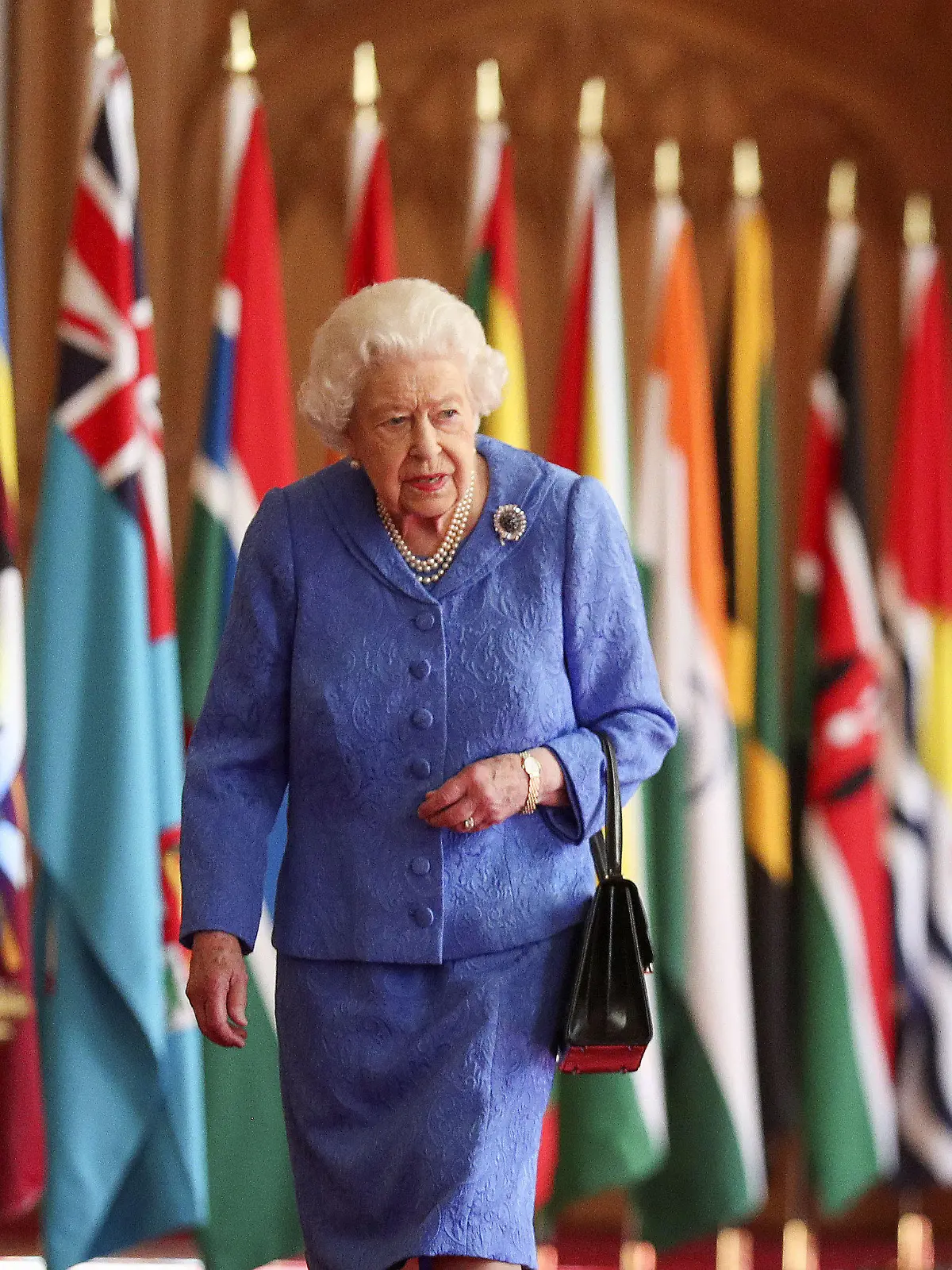 06.03.2021, Großbritannien, Windsor: Die britische Königin Elizabeth II. geht im Rahmen des Commonwealth-Tages in der St. George's Hall auf Schloss Windsor an den Flaggen der Mitgliedsländer des Commonwealth vorbei. Foto: Steve Parsons/PA Wire/dpa +++ dpa-Bildfunk +++