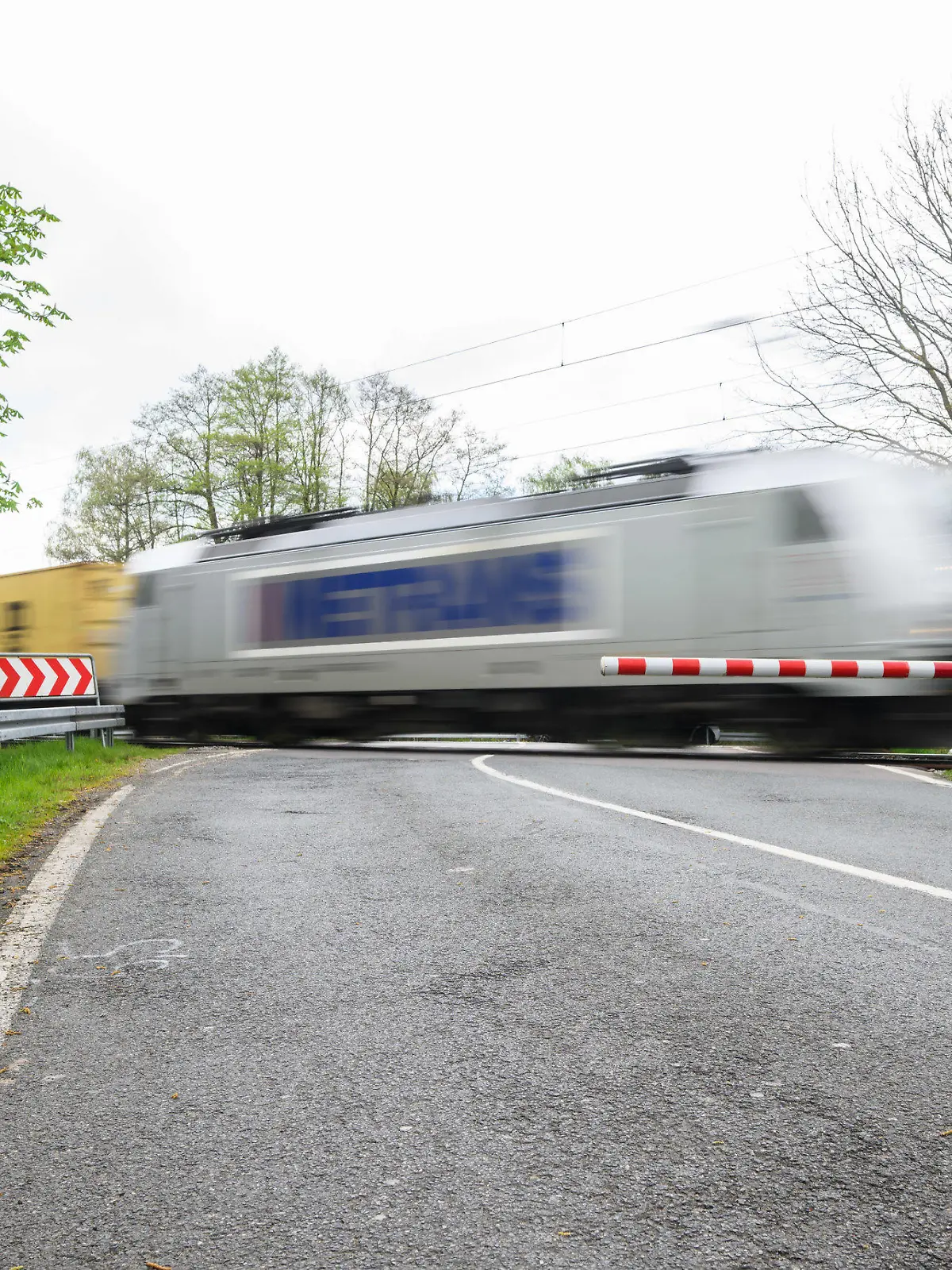 24.04.2023, Niedersachsen, Neustadt am Rübenberge: Ein Zug passiert den Bahnübergang, an dem am Sonntagmorgen ein Auto von einem Zug erfasst worden war. Nach dem tödlichen Unfall in der Region Hannover setzt die Polizei alles daran, die Ursache zu klären. Bei dem Unfall waren am frühen Sonntagmorgen (23.04.2023) drei junge Menschen gestorben, als ihr Auto auf dem Bahnübergang von einer Regionalbahn erfasst wurde. Nach Polizeiangaben waren sie trotz geschlossener Halbschranken auf den Bahnübergang gefahren. Foto: Julian Stratenschulte/dpa +++ dpa-Bildfunk +++