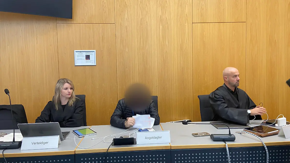 17.04.2025, Baden-Württemberg, Ulm: Ein Angeklagter sitzt zwischen seinen Verteidigern Jana Gieren und Andreas Baier im Gerichtssaal im Landgericht. Der Mann aus dem Alb-Donau-Kreis soll den sexuellen Missbrauch von Kindern auf den Philippinen in Auftrag gegeben und dafür bezahlt haben, sich die schweren Missbrauchshandlungen per Livestream ansehen zu können. Am Donnerstag hat der Prozess begonnen. Foto: Tatjana Bobic/dpa - ACHTUNG: Der Angeklagte wurde auf Wusch seiner Verteidiger gepixelt. Auch Informationen auf einem Zettel, den er hält, wurden aus rechtlichen Gründen gepixelt. +++ dpa-Bildfunk +++