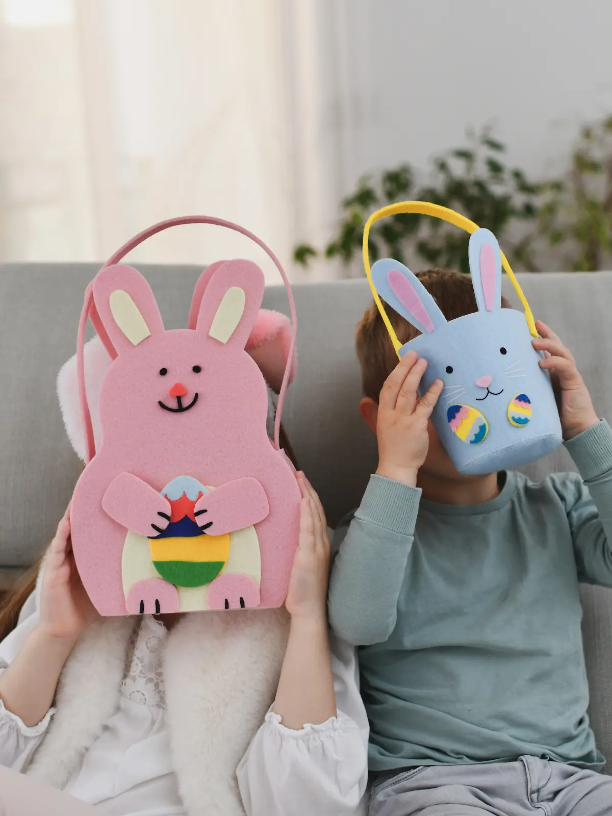 Kinder verstecken ihr Gesicht hinter ihren Oster-Geschenken.