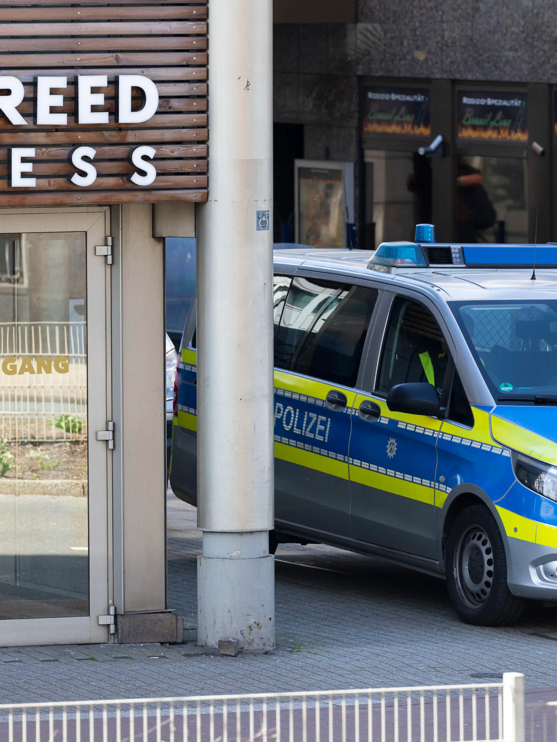 19.04.2023, Nordrhein-Westfalen, Duisburg: Ein Streifenwagen steht vor dem Eingang. Bei einer Attacke in einem Fitnessstudio in der Duisburger Innenstadt sind mehrere Personen schwer verletzt worden. Die Polizei sprach am Dienstagabend von «mindestens» einem Täter. Foto: Christoph Reichwein/dpa +++ dpa-Bildfunk +++
