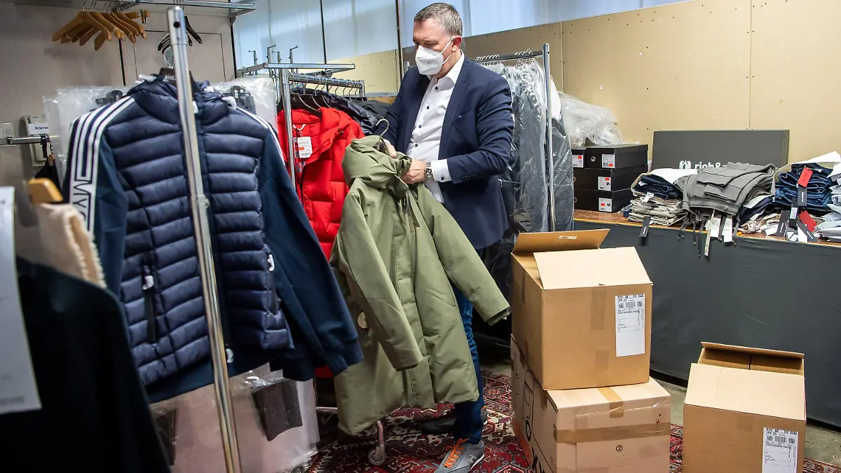 02.03.2021, Bremen: Jens Ristedt sortiert im Lager seines Modehauses die unverkaufte Winterkleidung. Der Frühling kommt, doch die Mode- und Schuhgeschäfte im Norden sitzen immer noch auf der Winterware, die sie im Corona-Lockdown nicht verkaufen konnten. Foto: Sina Schuldt/dpa +++ dpa-Bildfunk +++