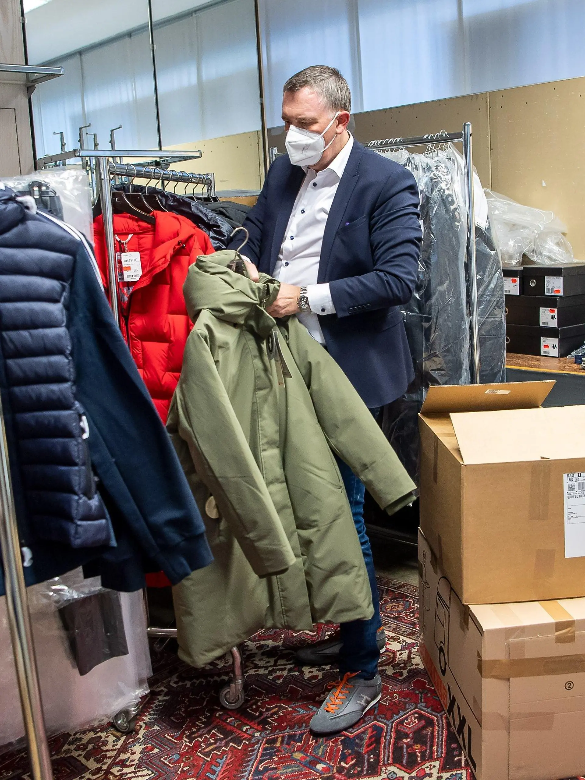 02.03.2021, Bremen: Jens Ristedt sortiert im Lager seines Modehauses die unverkaufte Winterkleidung. Der Frühling kommt, doch die Mode- und Schuhgeschäfte im Norden sitzen immer noch auf der Winterware, die sie im Corona-Lockdown nicht verkaufen konnten. Foto: Sina Schuldt/dpa +++ dpa-Bildfunk +++