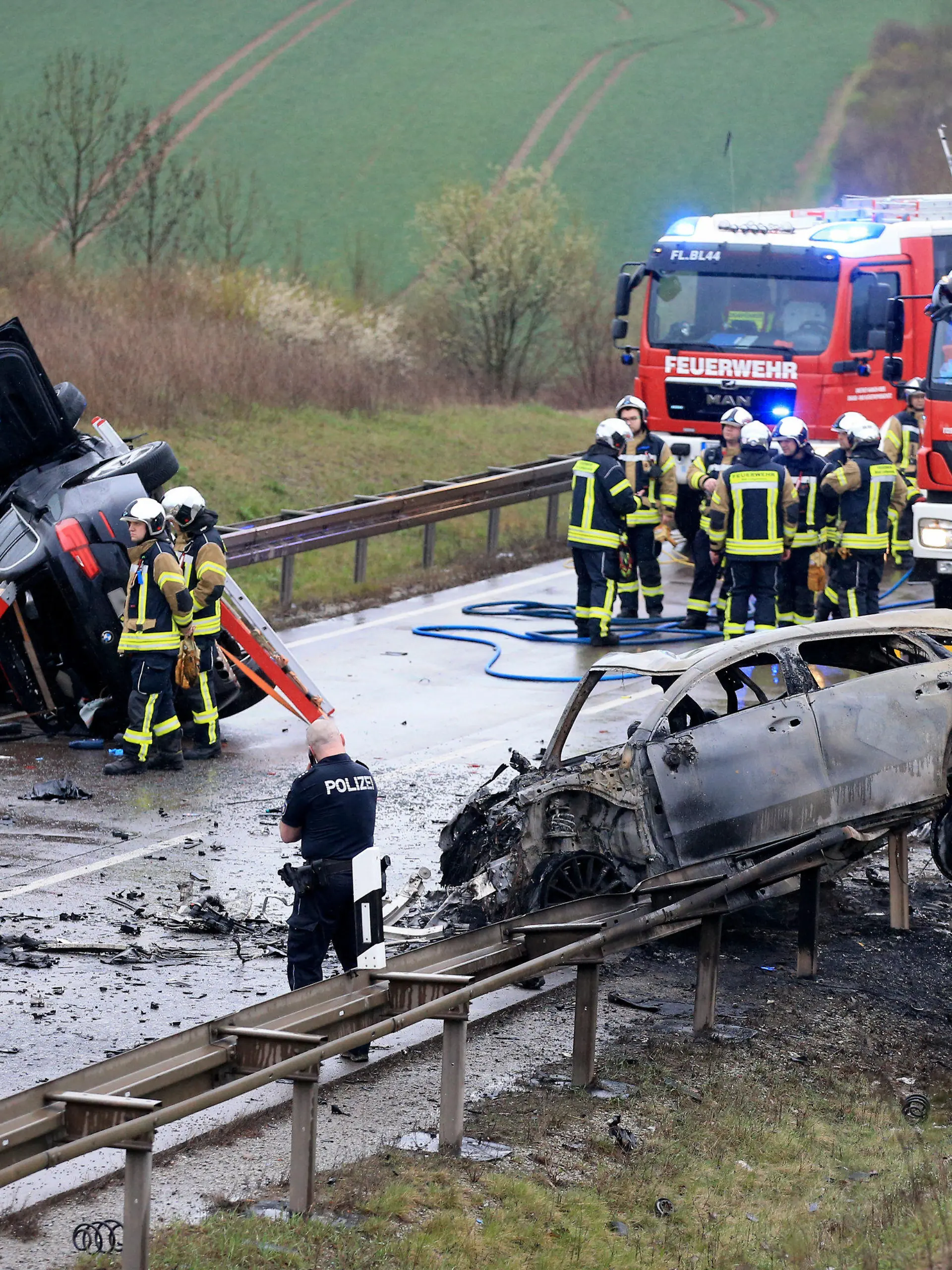 dpatopbilder - 01.04.2023, Thüringen, Bad Langensalza: Ein ausgebrannter PKW und ein weiteres verunfalltes Fahrzeug stehen an der Unfallstelle auf der B247 bei Bad Langensalza. Bei einem schweren Verkehrsunfall im Norden Thüringens sind am späten Samstagnachmittag nach Polizeiangaben mehrere Menschen ums Leben gekommen. An dem Unfall waren drei Fahrzeuge beteiligt von denen zwei in Flammen gerieten. Foto: Silvio Dietzel/dpa-Zentralbild/dpa +++ dpa-Bildfunk +++