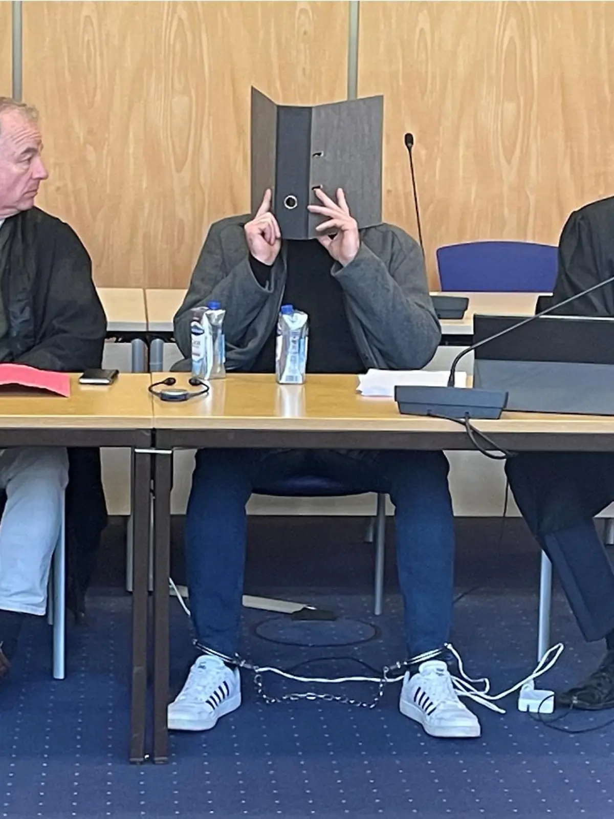 Vor Gericht verdeckte der Angeklagte sein Gesicht mit einem Ordner.