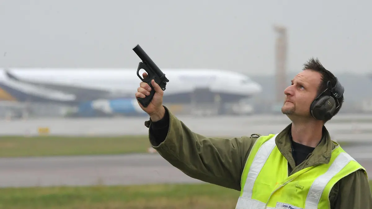 Ornithologe Jürgen von Ramin von der sogenannten «Bird Control» auf dem Flughafen Hannover scheucht am Dienstag (06.10.2009) mit einem Knall aus einer Signalpistole auf dem Flughafen in Hannover die Vögel auf. Ramin beobachtet täglich das Areal rund um die Start- und Landebahnen am Flughafen Hannover und sorgt dafür, dass möglichst keine Vögel mit den Flugzeugen zusammenstoßen oder in die Triebwerke der Maschinen fliegen. Denn das kann katastrophale Folgen haben und zu schweren Unfällen führen. Foto: Peter Steffen dpa/lni (zu dpa-Korr: "Mit Schreckschuss und Diensttaube: Vögel verjagen am Airport" vom 14.10.2009) +++(c) dpa - Bildfunk+++