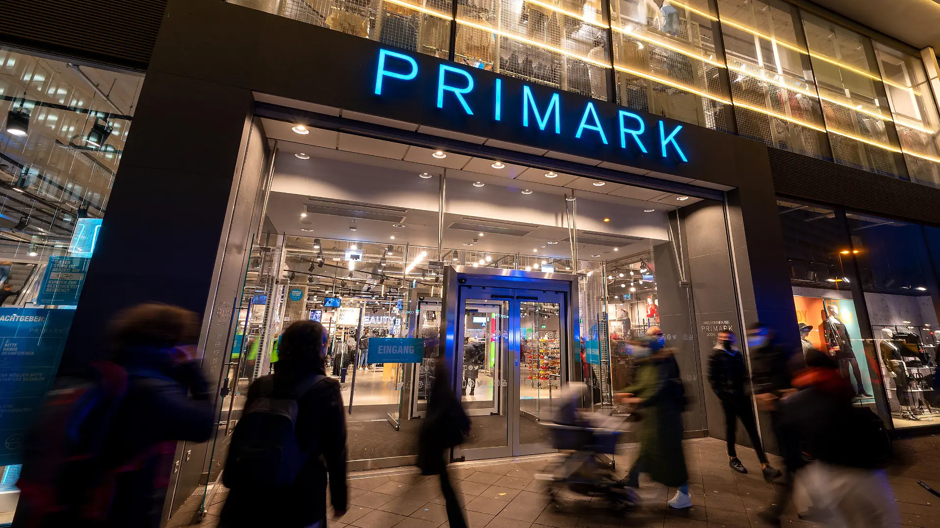 Passanten gehen am Abend an dem Bekleidungsgeschäft Primark vorbei.